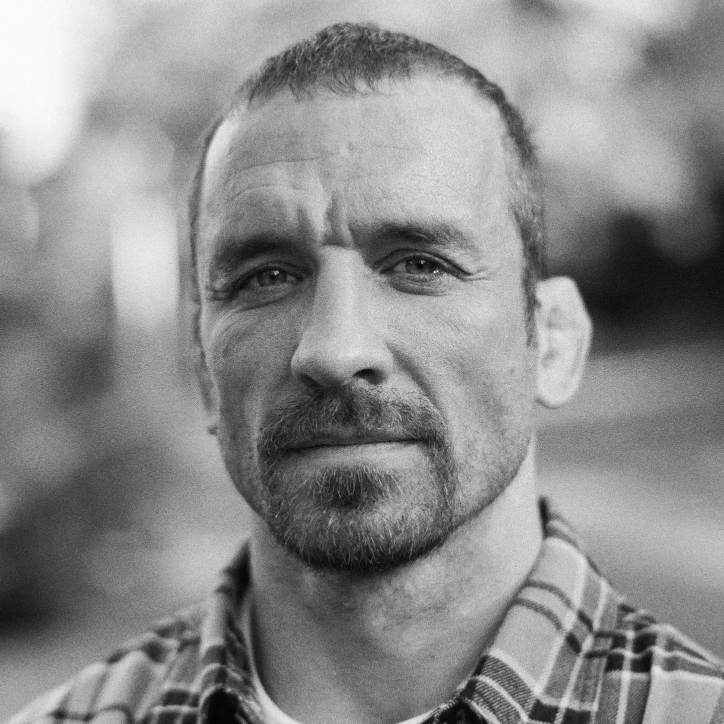 A smiling man wearing a baseball cap and a T-shirt with the logo 'MAB STUNTS' gives two thumbs up. The background suggests an outdoor setting with a vehicle or structure.