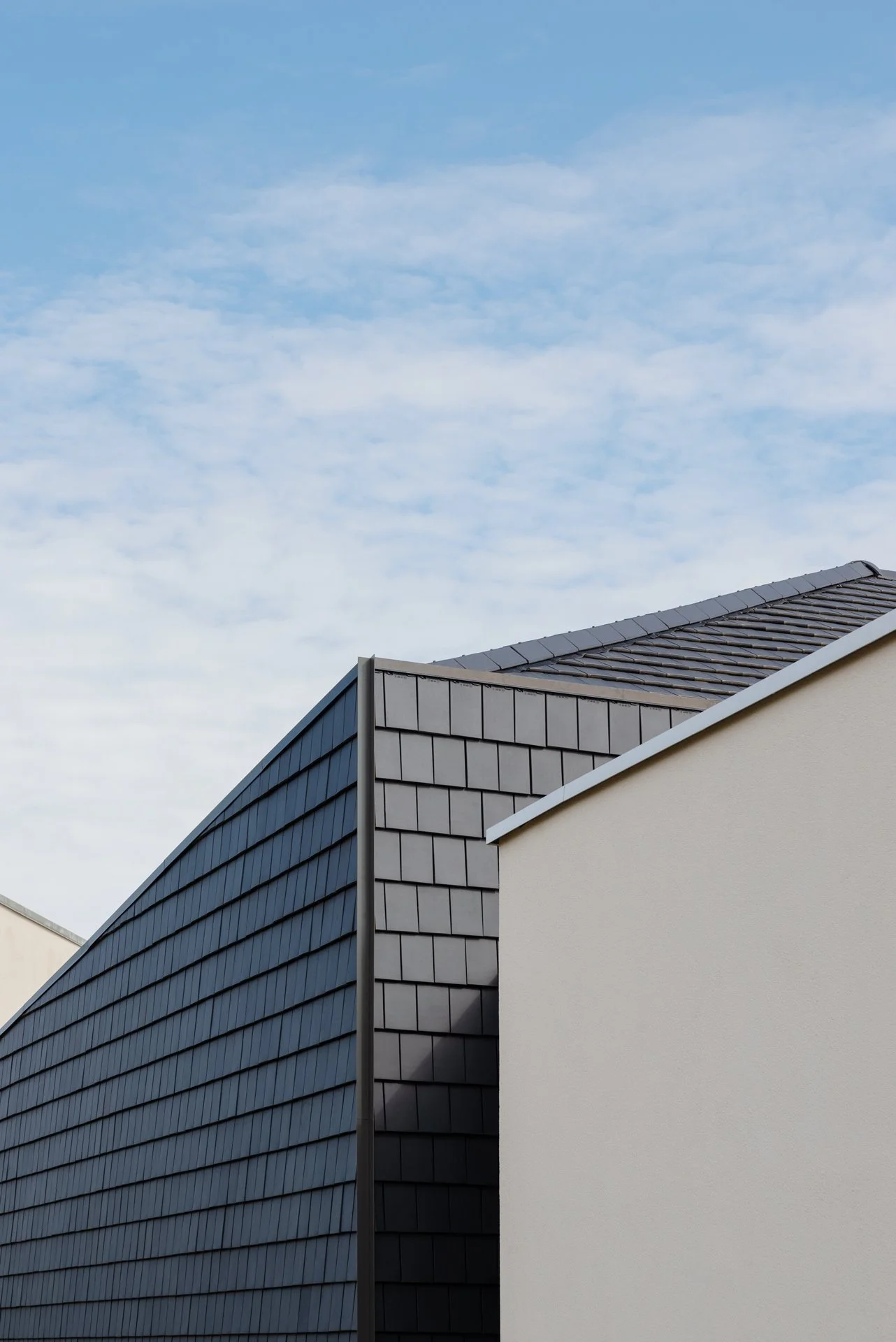 Toits de bâtiments modernes avec ciel bleu et nuages.