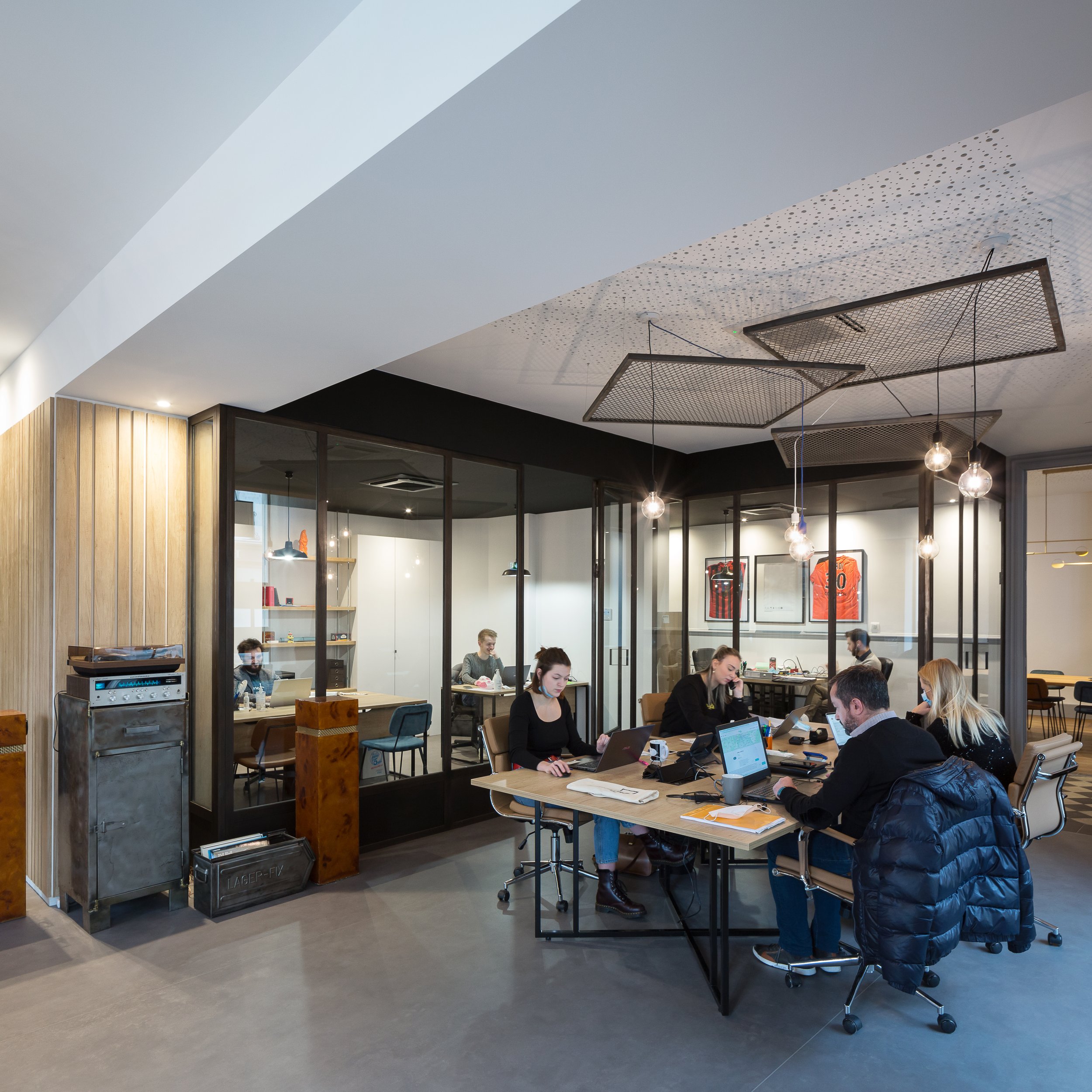 Espace de travail en open space de l'agence immobilière après réalisation des travaux.