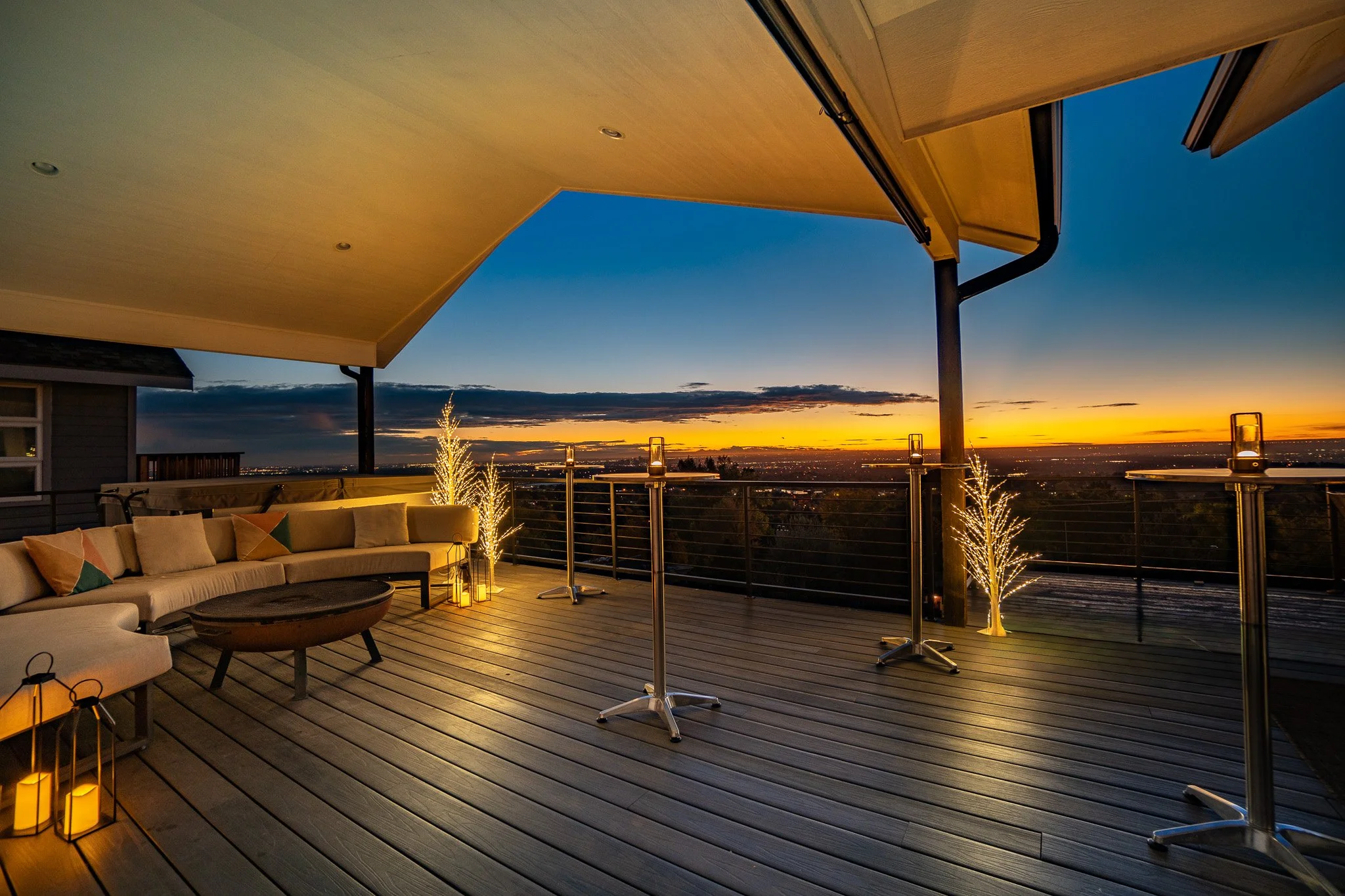 Sunset view on the panoramic sky deck at Denver Skyline Venue set for a cocktail reception with cocktail tables and lighted trees