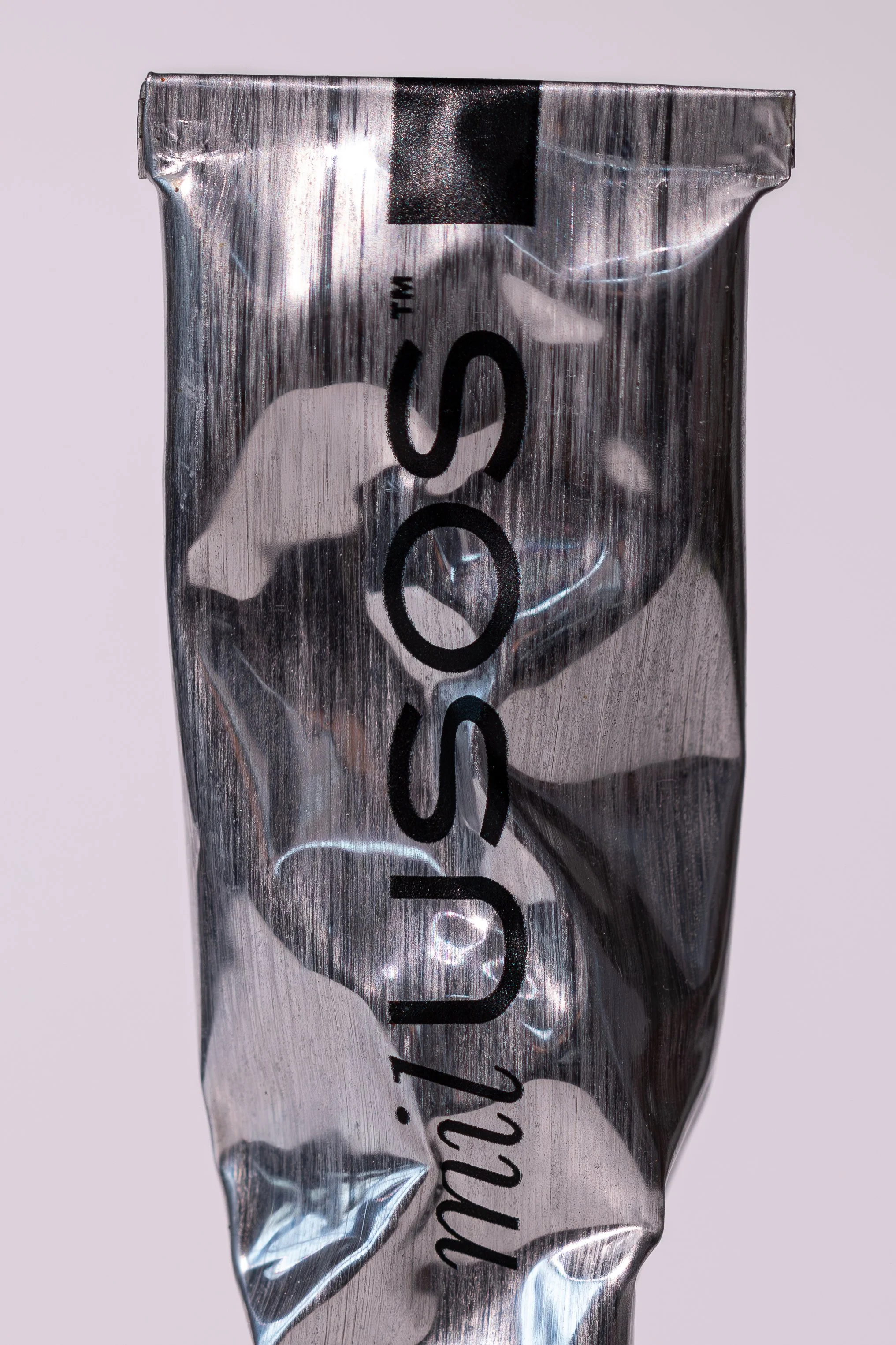 Close-up of a metallic, crinkled energy drink can with black text that reads "the SCOUNDREL" and some other writing partially visible.