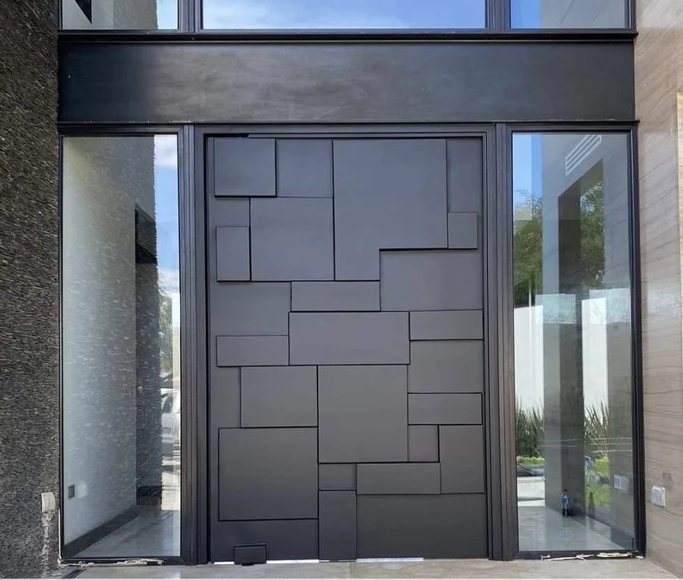 Modern black and gray front entrance with geometric patterned door, flanked by large glass windows.