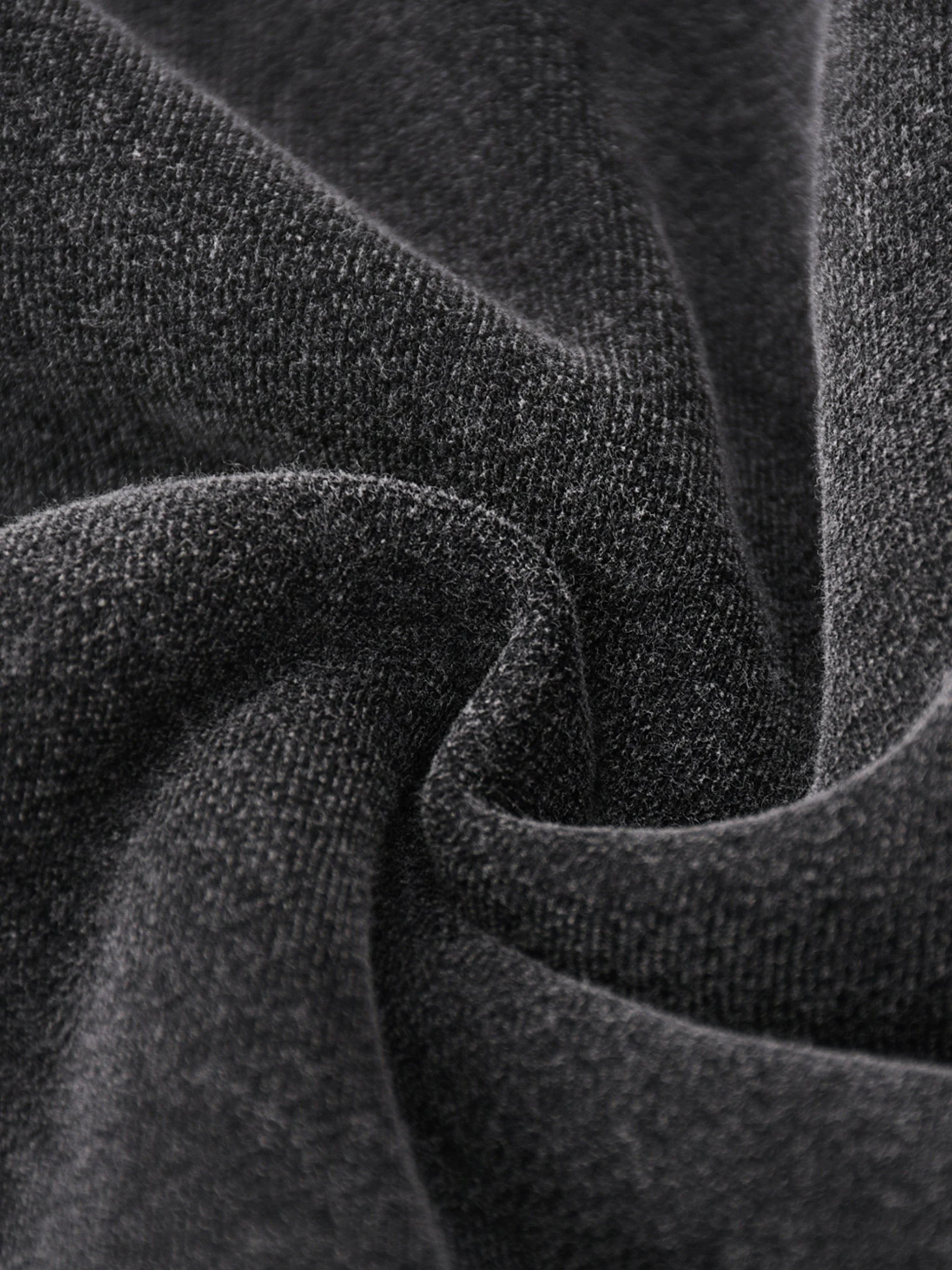 Close-up of dark gray fabric with a soft, textured surface and gentle folds.