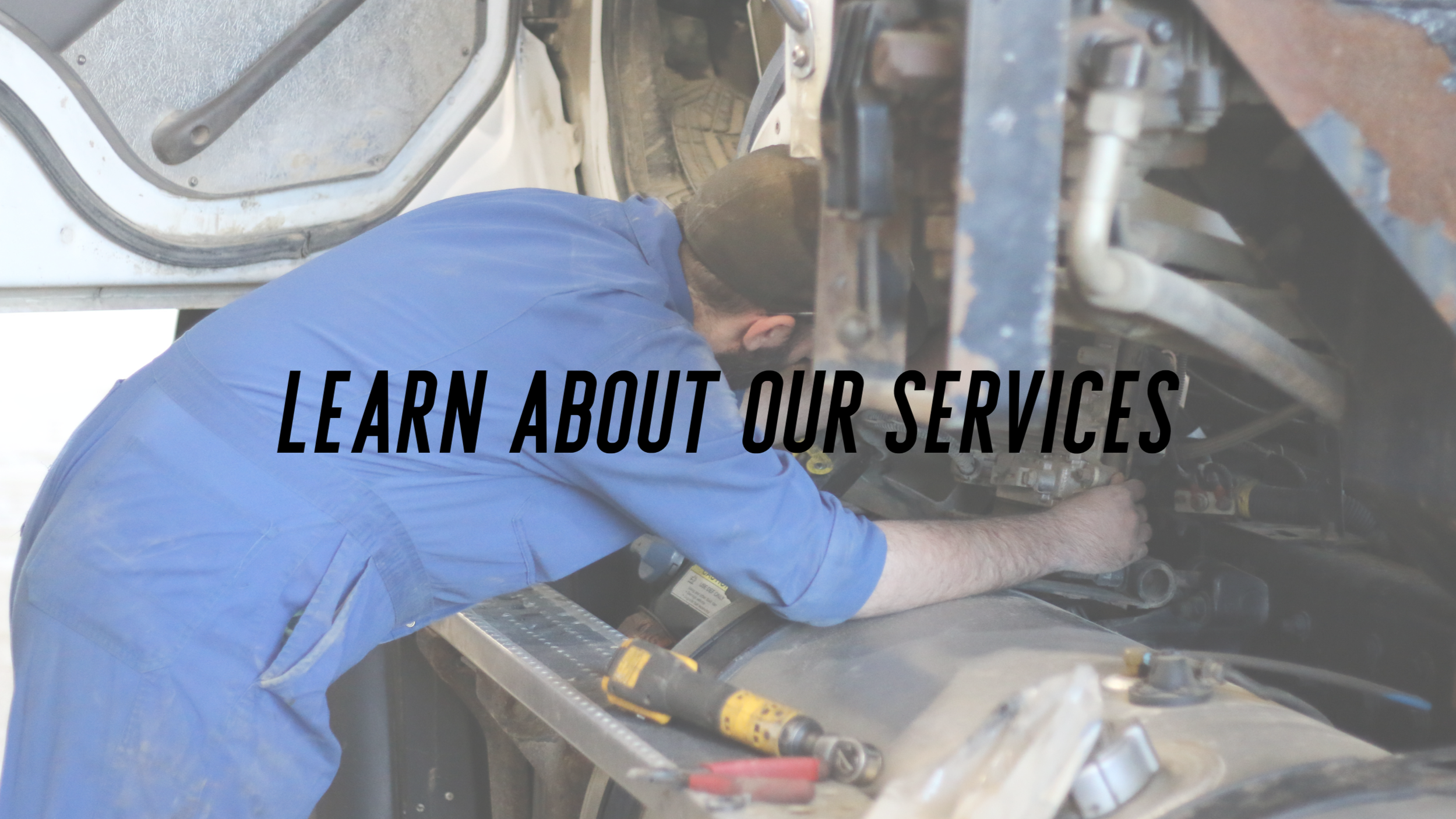 A mechanic working underneath a vehicle, with tools nearby, with overlay text "Learn About Our Services".