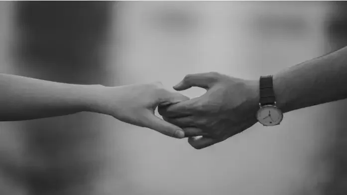 A couple holding hands by a river, symbolizing connection and healing in relationships with anxious attachment.