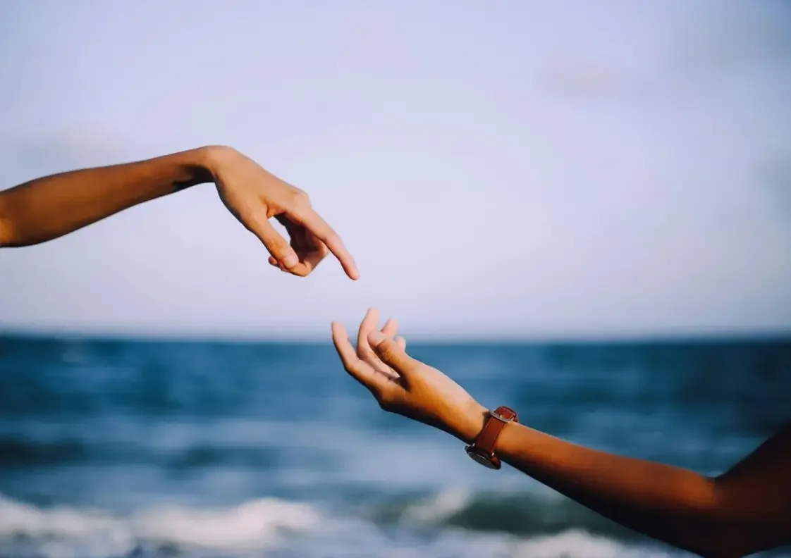 Two hands reaching toward each other - Liminality Professional Psychotherapy.webp