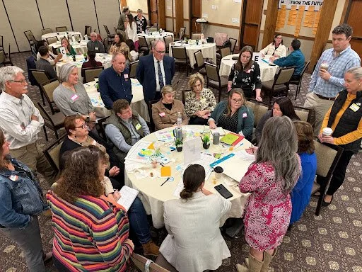 Group working at a table to establish regional priorities for DegenSTEAM