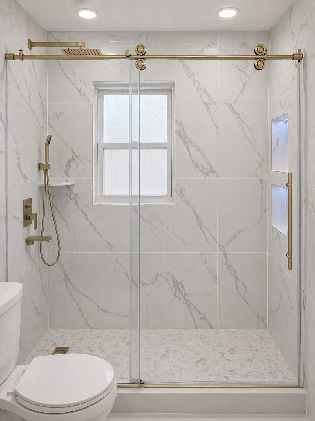 Modern walk-in shower with marble tiles, gold fixtures, a window, and frosted glass sliding doors.