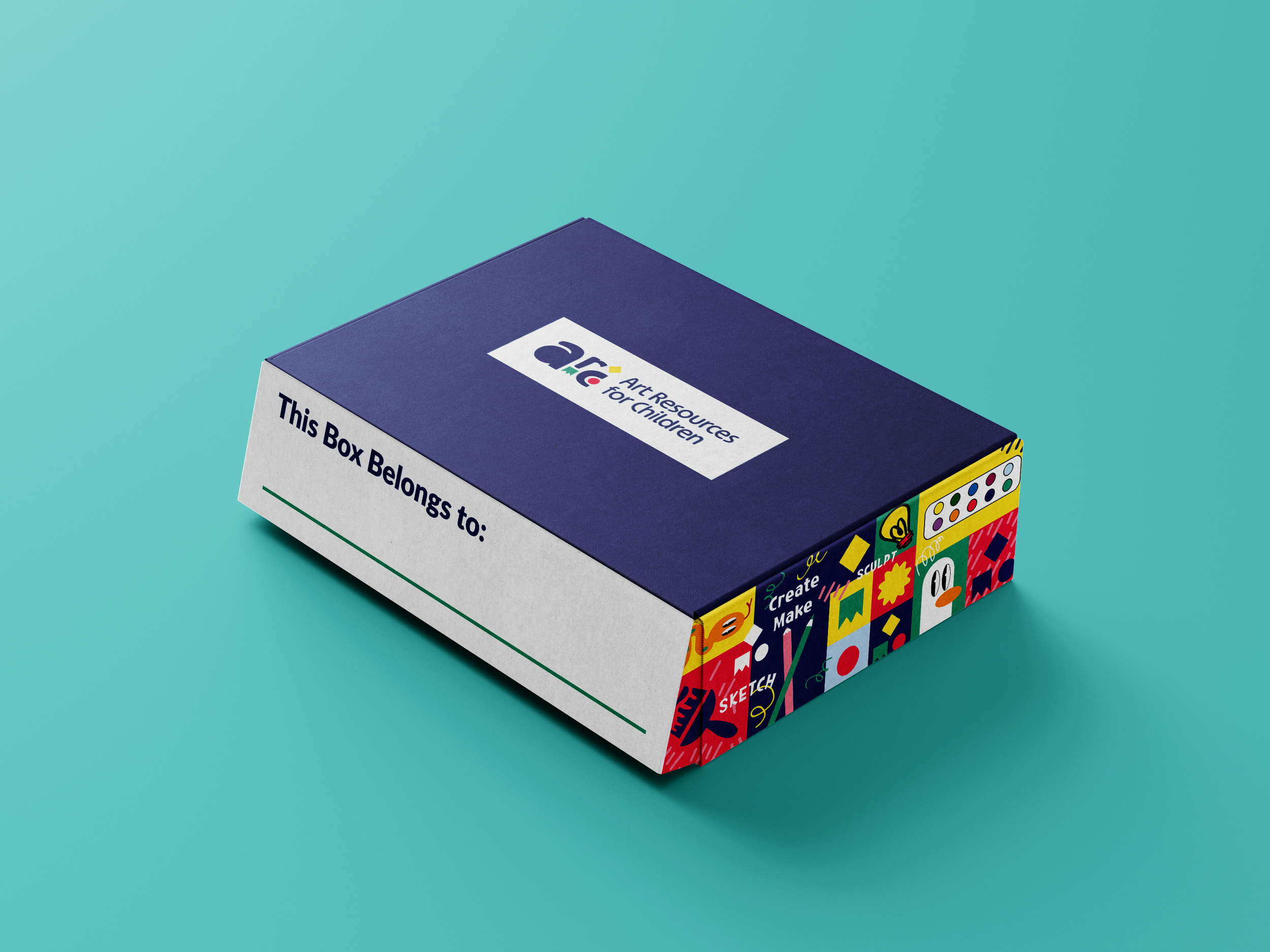 A rectangular box with a blue lid and white label on top reading 'This Box Belongs to:' with space for writing a name. The side of the box features colorful art supplies and craft-related illustrations, including paintbrushes, palettes, and various a