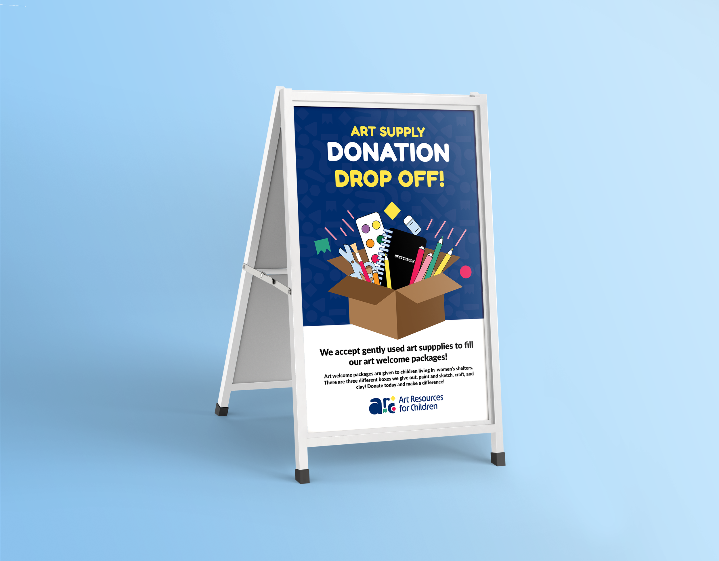 A white sandwich board sign with a poster advertising art supply donations, featuring a box filled with art supplies like paintbrushes, pencils, and a sketchbook, on a blue background.