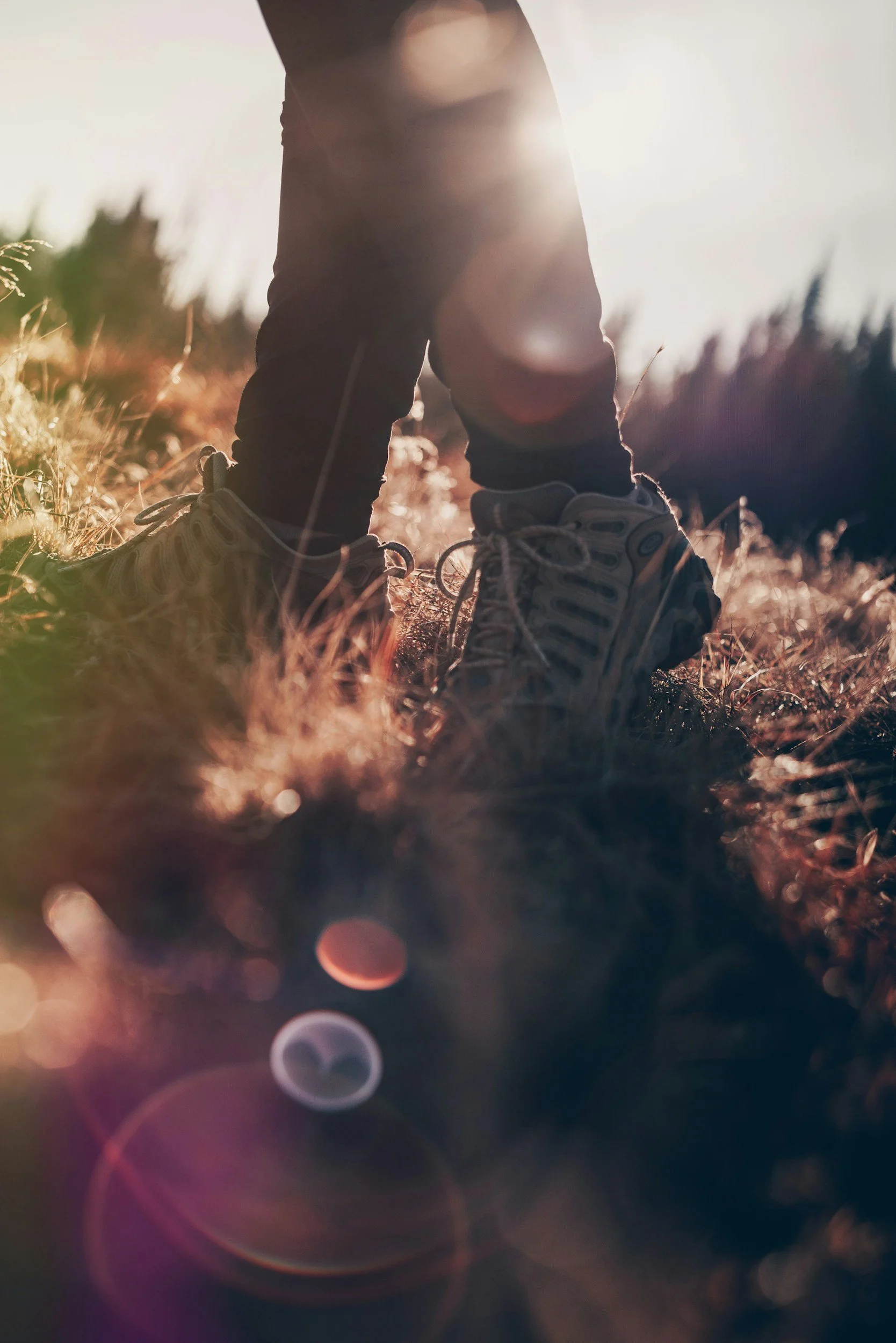 Wandelschoenen in het gras tijdens een coach hike in de natuur van Luxemburg met wandelen, coaching en ademwerk.