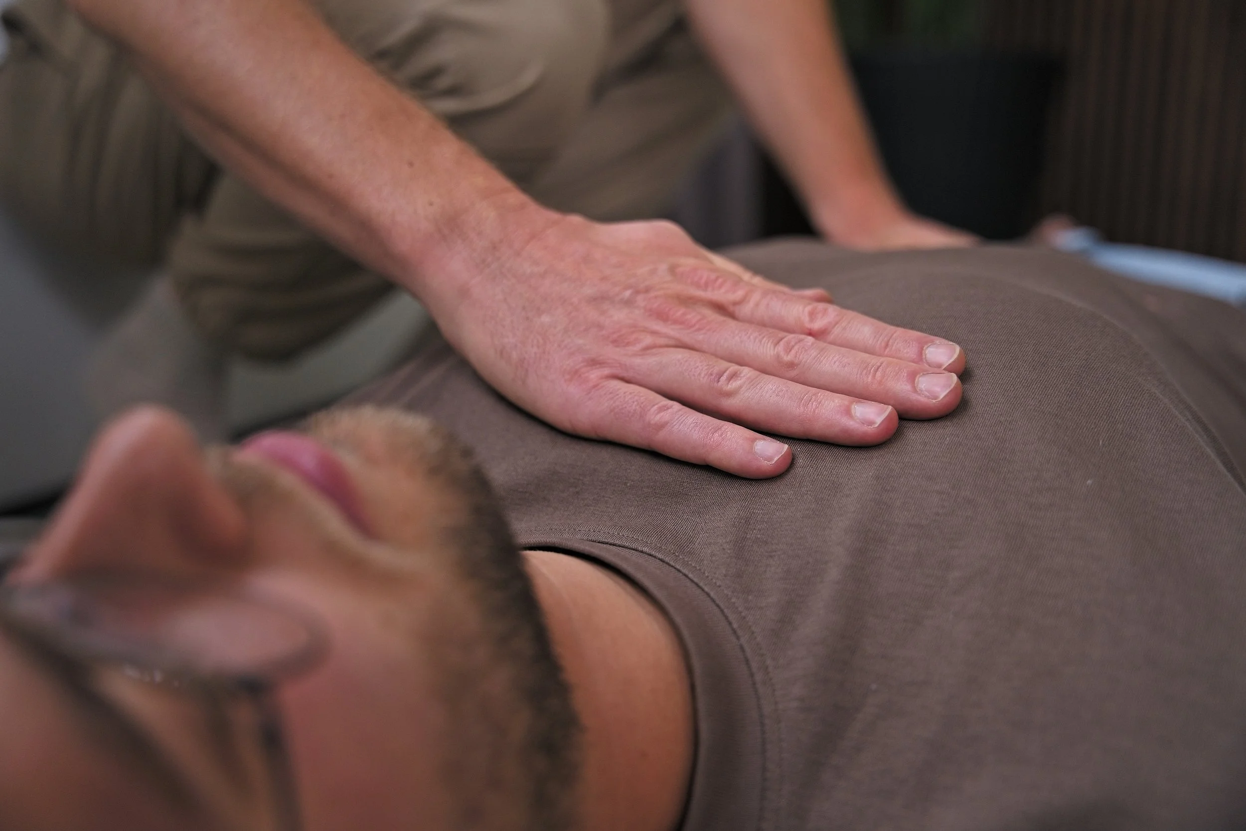 Persoon met hand op borst tijdens individuele ademwerk sessie