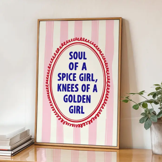 Framed poster with pink and white vertical stripes background and a red oval border containing the quote: 'Soul of a spice girl, knees of a golden girl' in bold blue letters.
