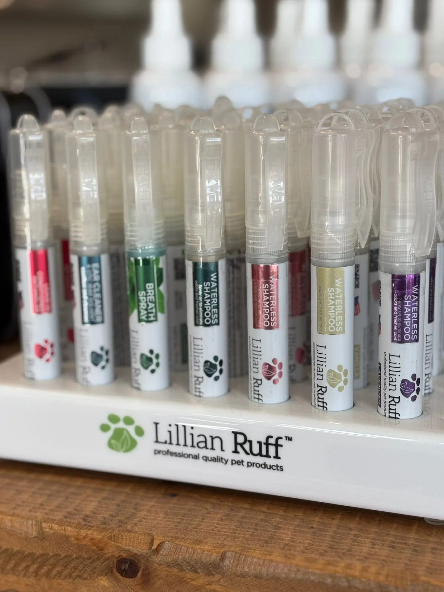 Set of Lillian RUFF waterless shampoo sprays for pets in various colors, displayed in a white stand with the brand logo and description.