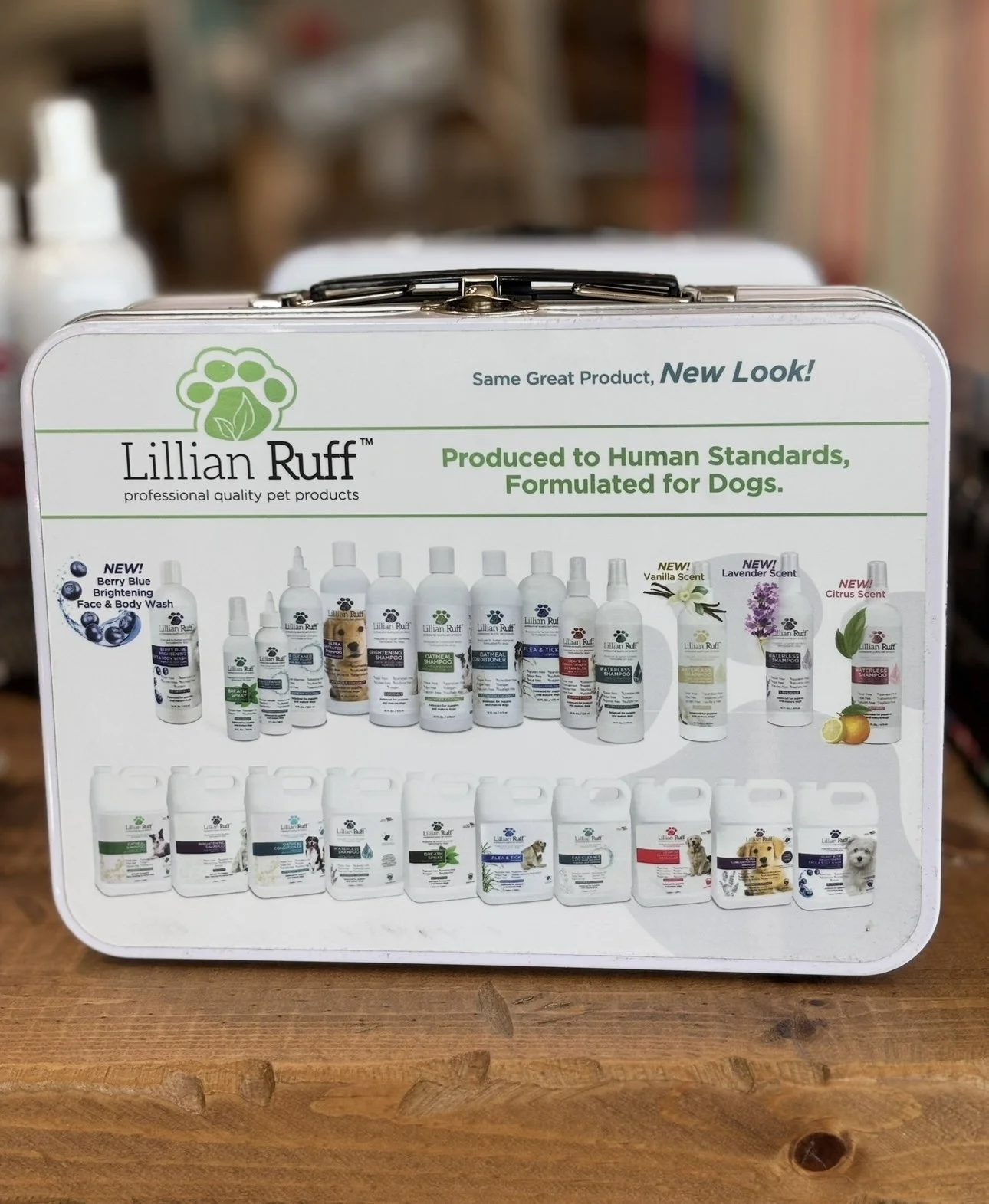 A metal case with various bottles of Lilian Ruff pet grooming products, including shampoos and sprays, displayed on the front, with some bottles labeled with pet images and scent options.