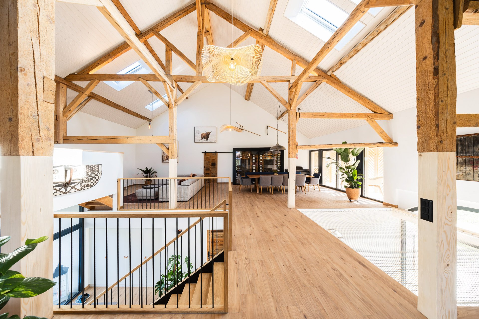 Intérieur de maison avec poutres apparentes et salle à manger lumineuse — projet Ton Projet Sàrl