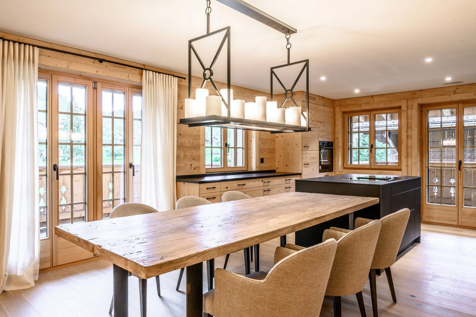 Salle à manger en bois avec larges baies vitrées — architecture intérieure Ton Projet Sàrl