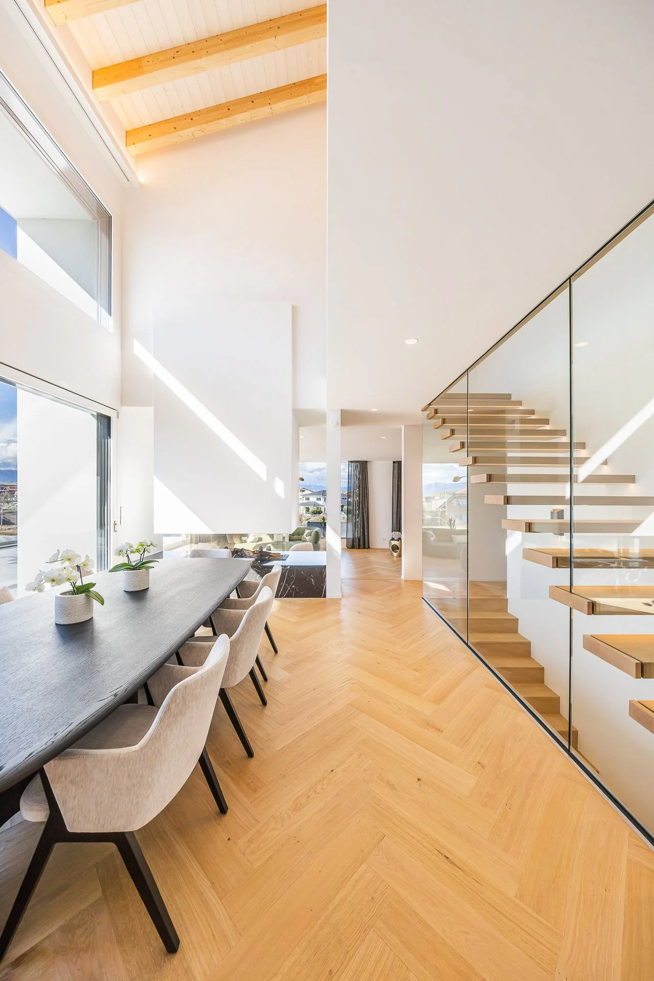Intérieur lumineux avec escalier en bois et salle à manger contemporaine — projet Ton Projet Sàrl