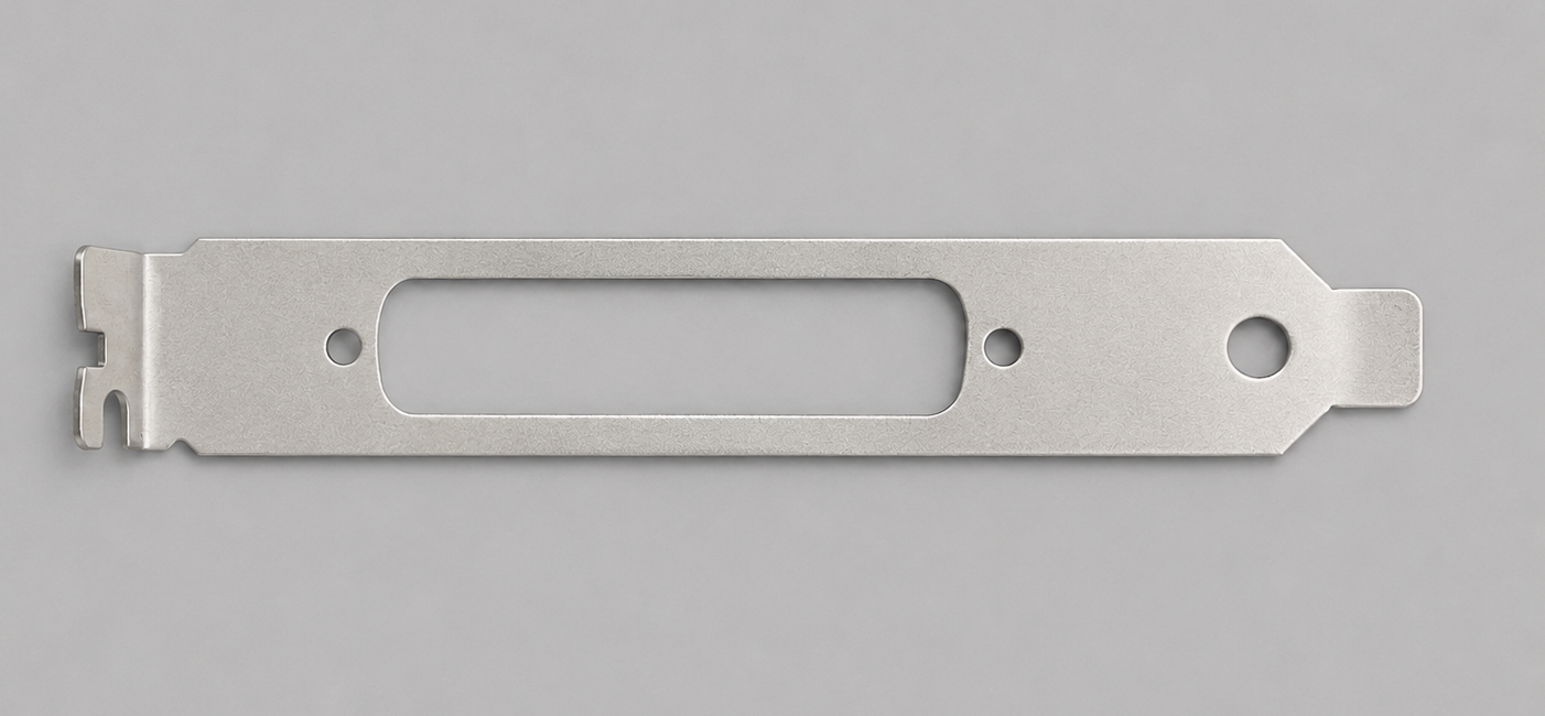 A flat, elongated metallic razor blade with a rectangular central cutout and holes on each end, lying on a gray background.