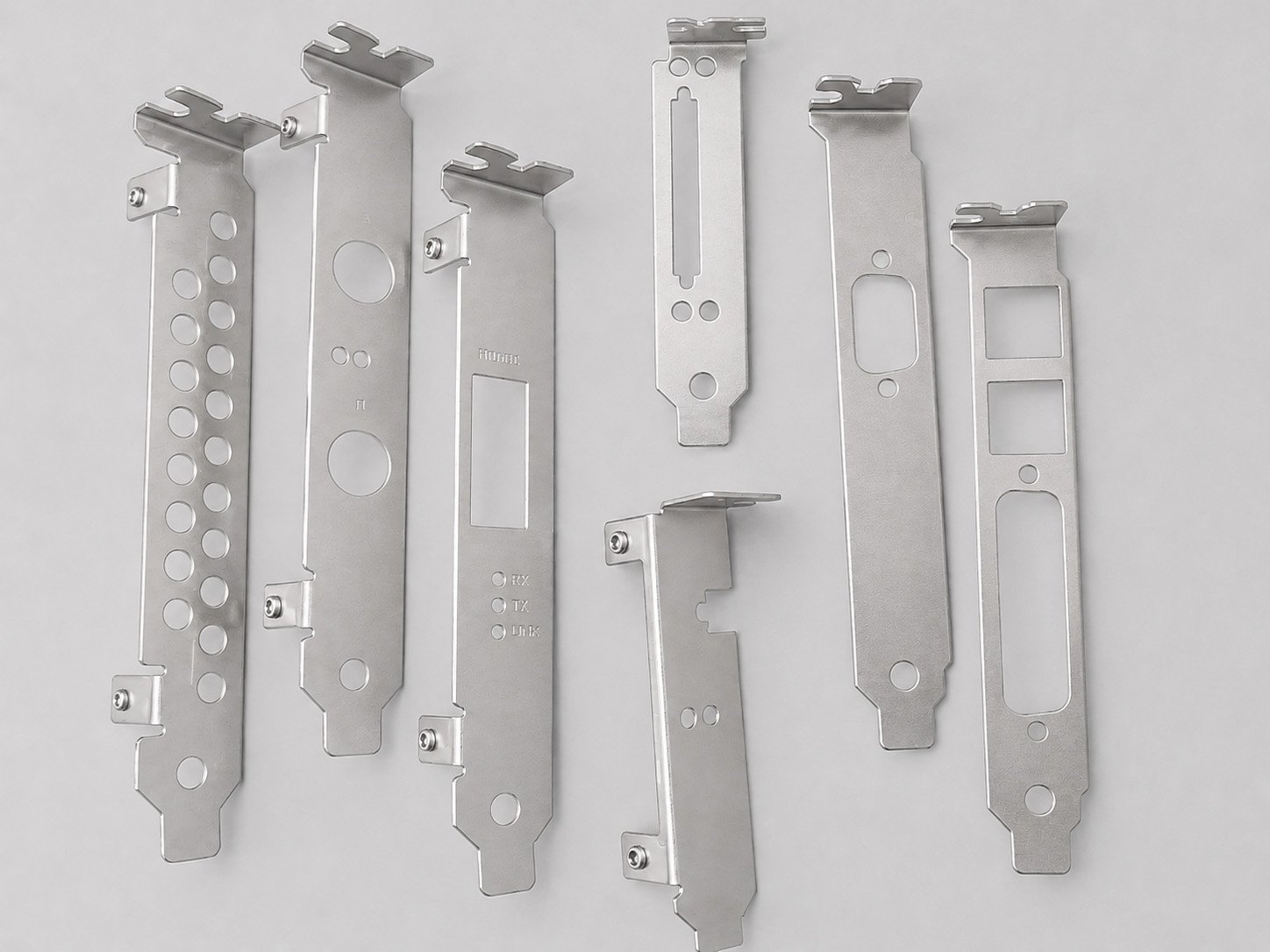 Seven metal mounting brackets of various sizes and shapes arranged on a white background.