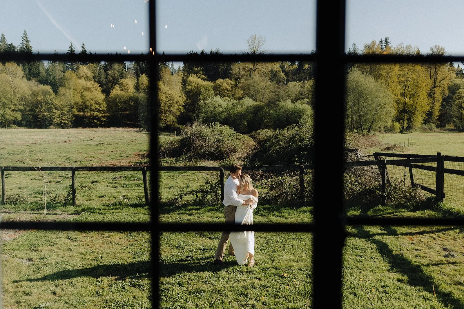 Bride and groom dancing in a sunny grass area