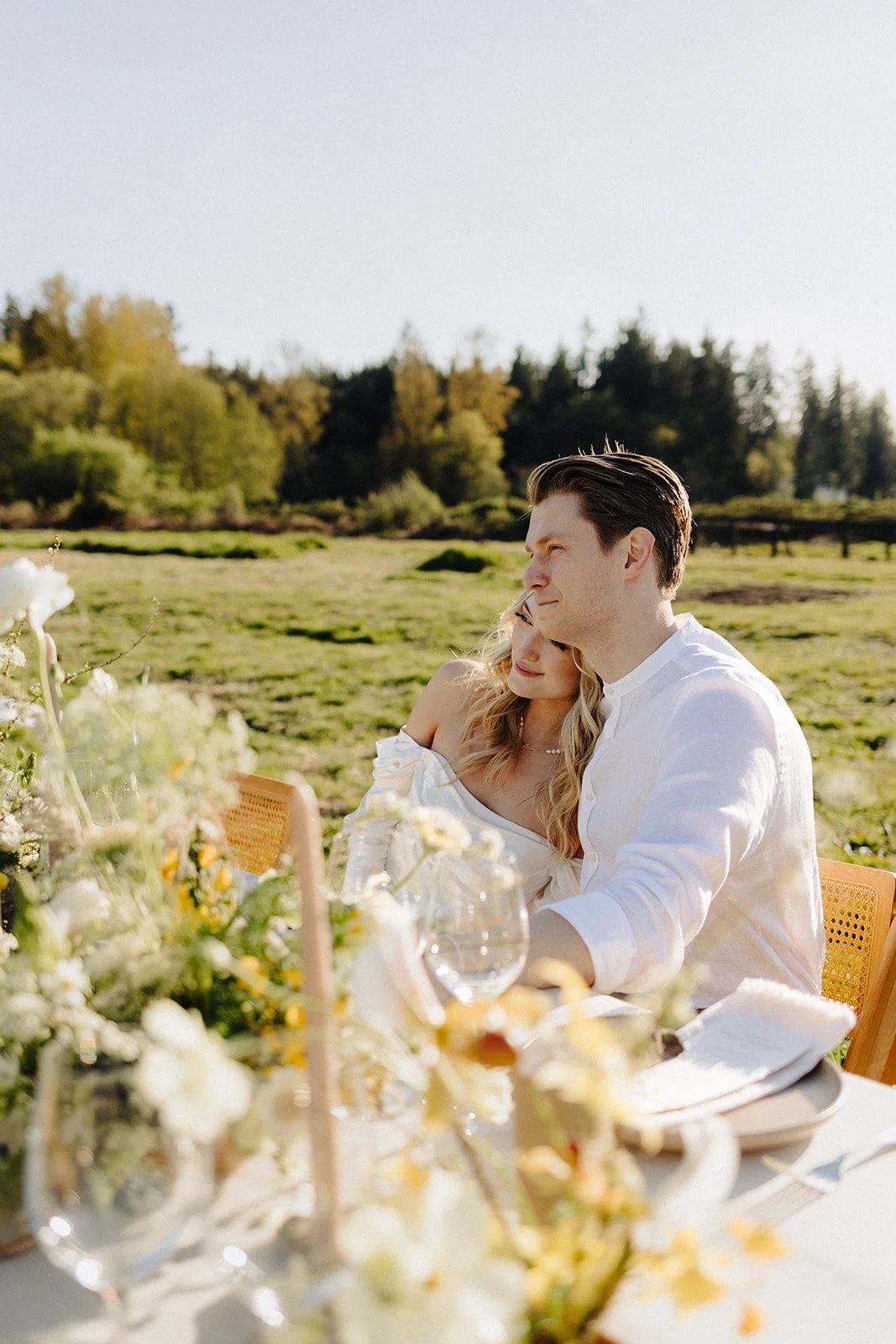 Bride and groom at wedding reception table in a grass field