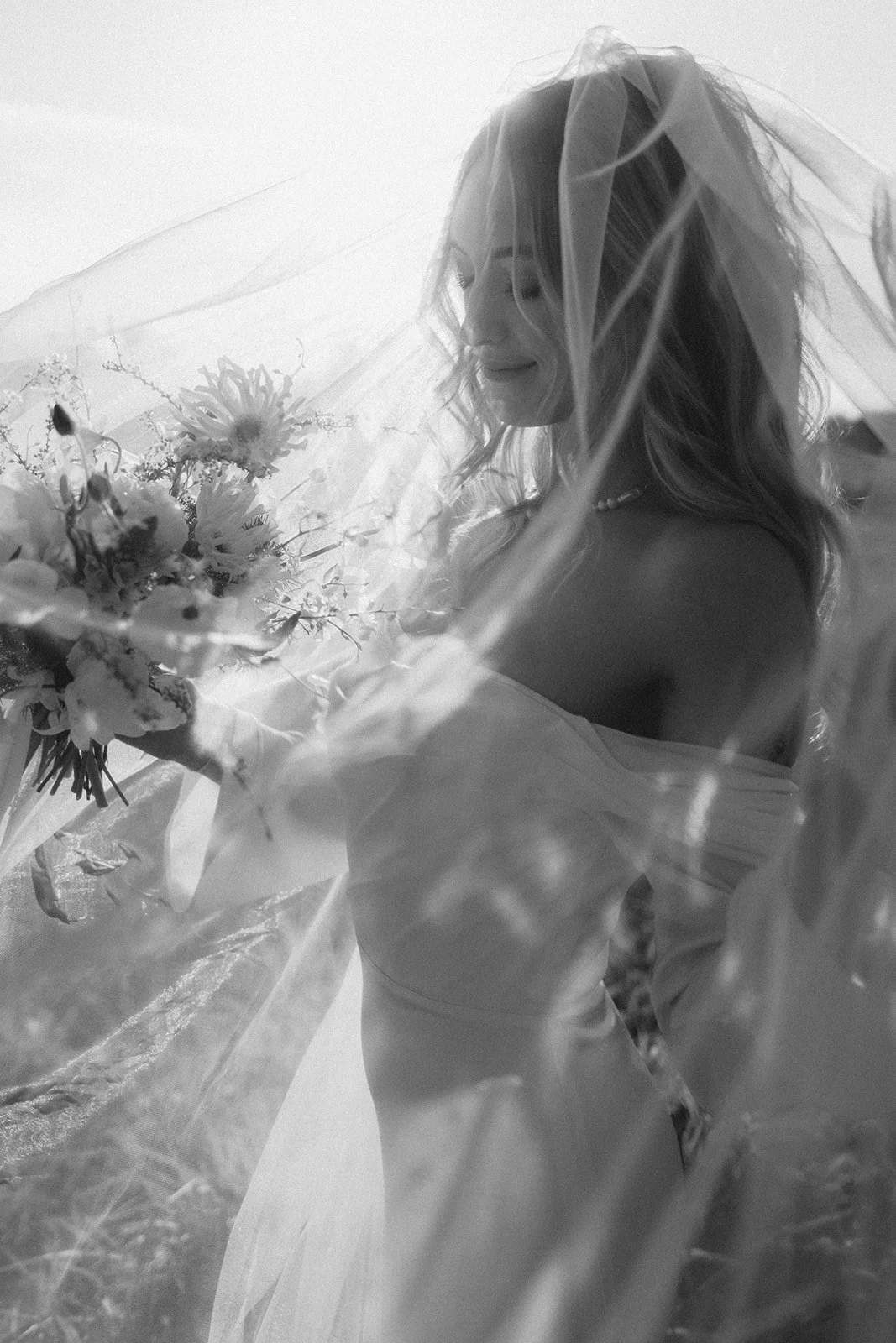 Bride holding a summer bouquet with veil on