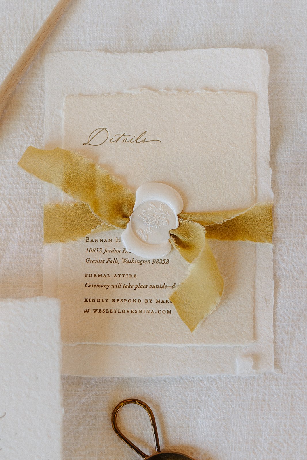 Stack of artisan stationery with delicate yellow silk ribbon with floral wax seal