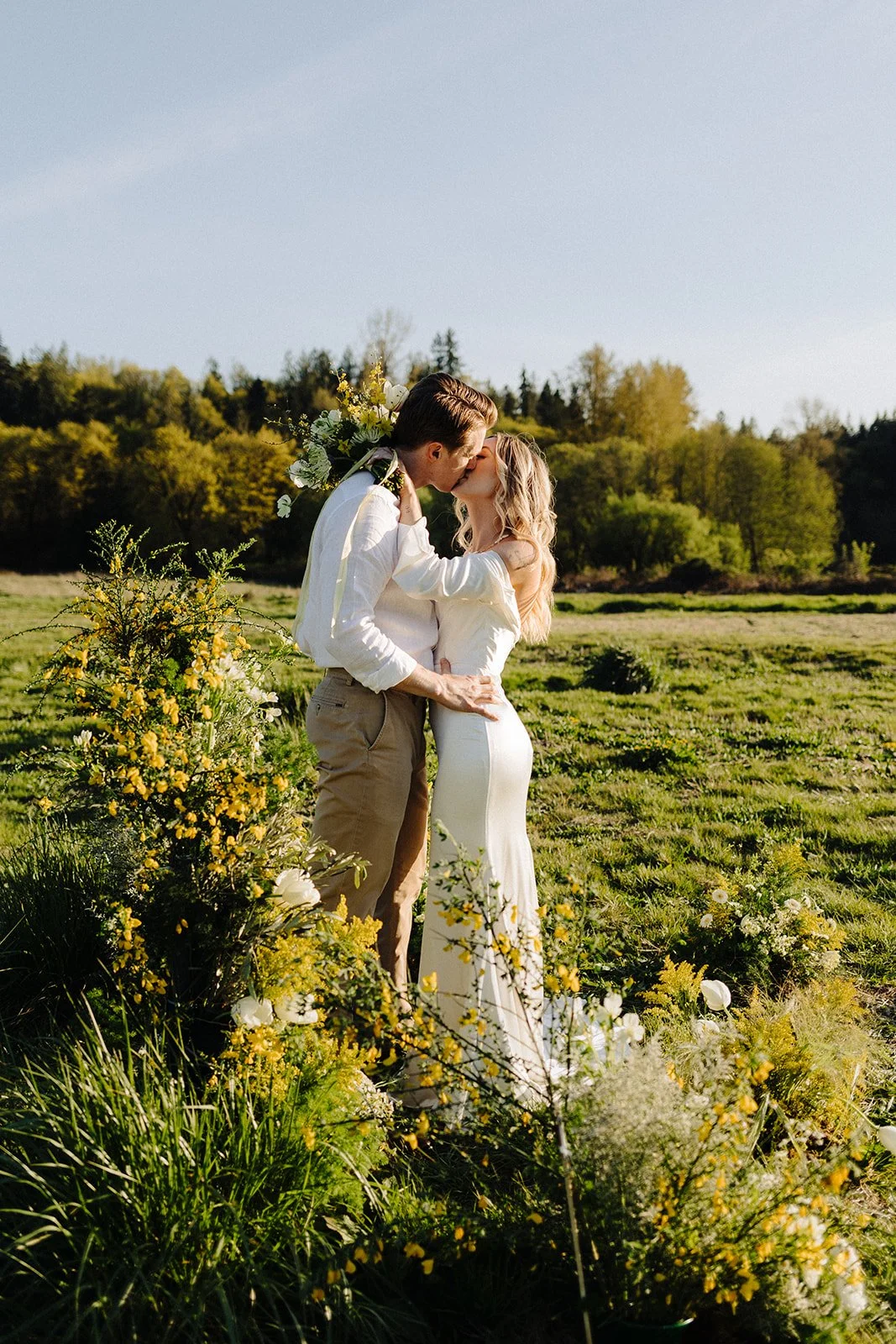 Bride and groom kissing in a sunny field at Bannan House Farm