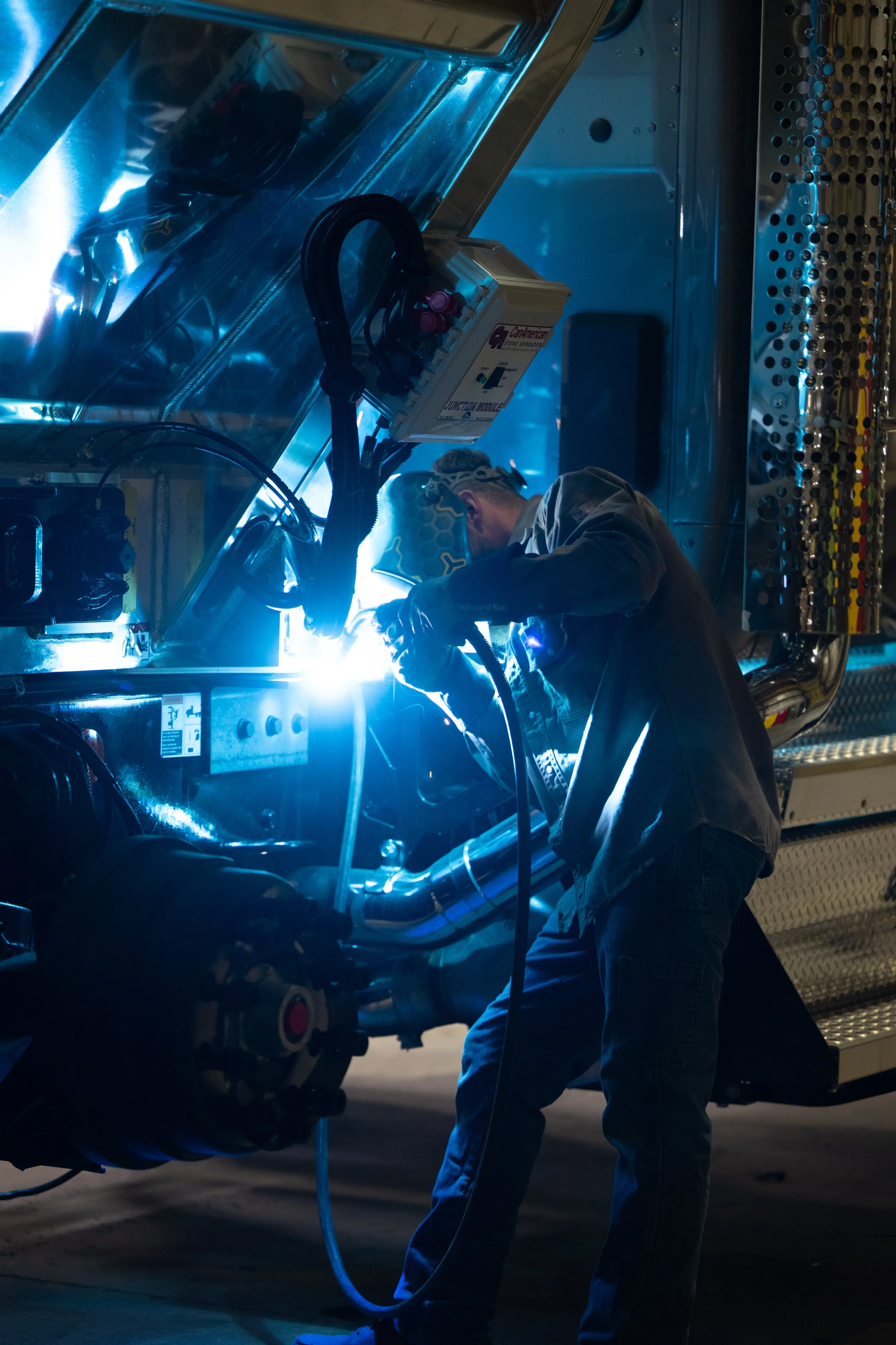 A worker welding on a GCI truck