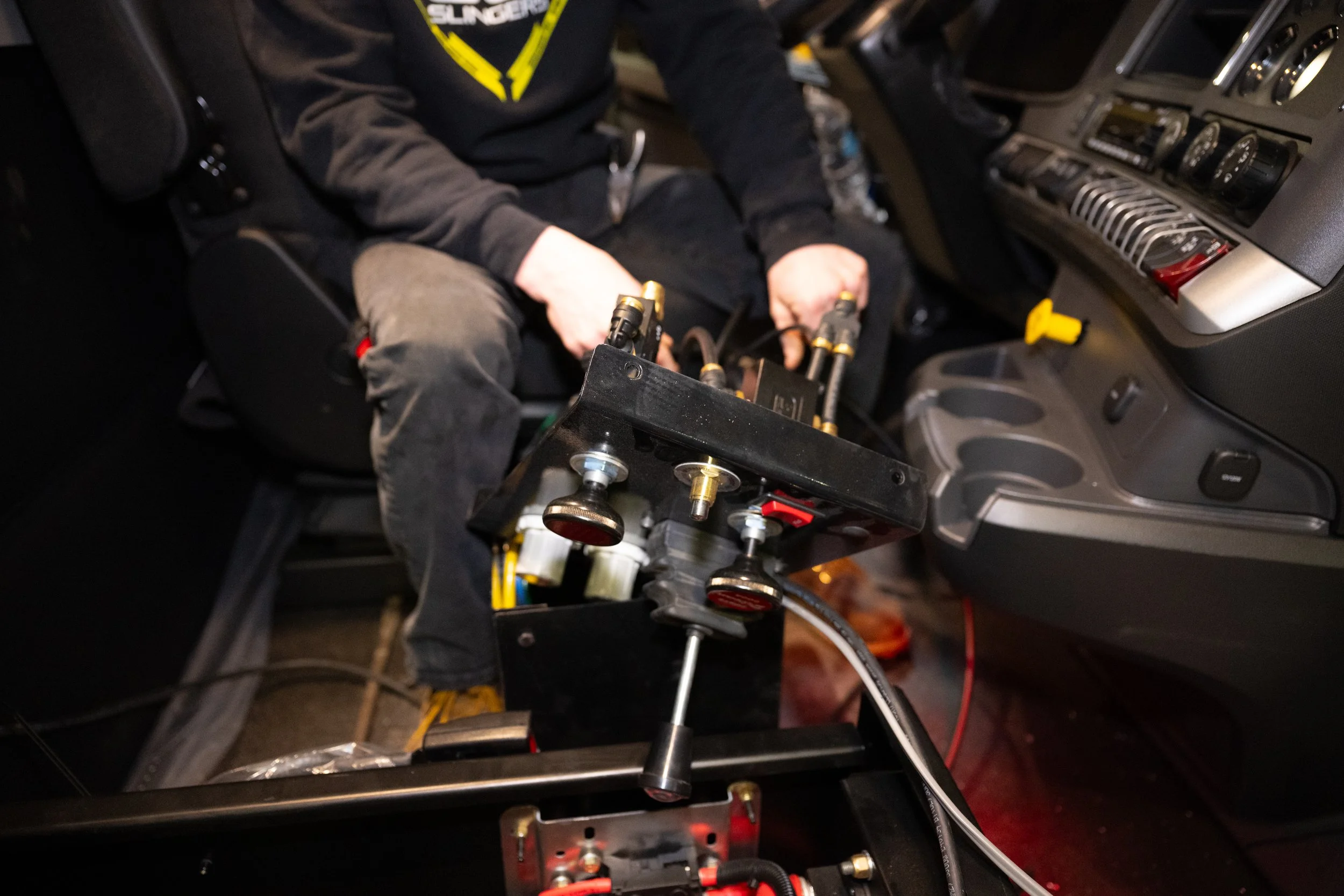 An employee in a GCI hoodie handling a truck part