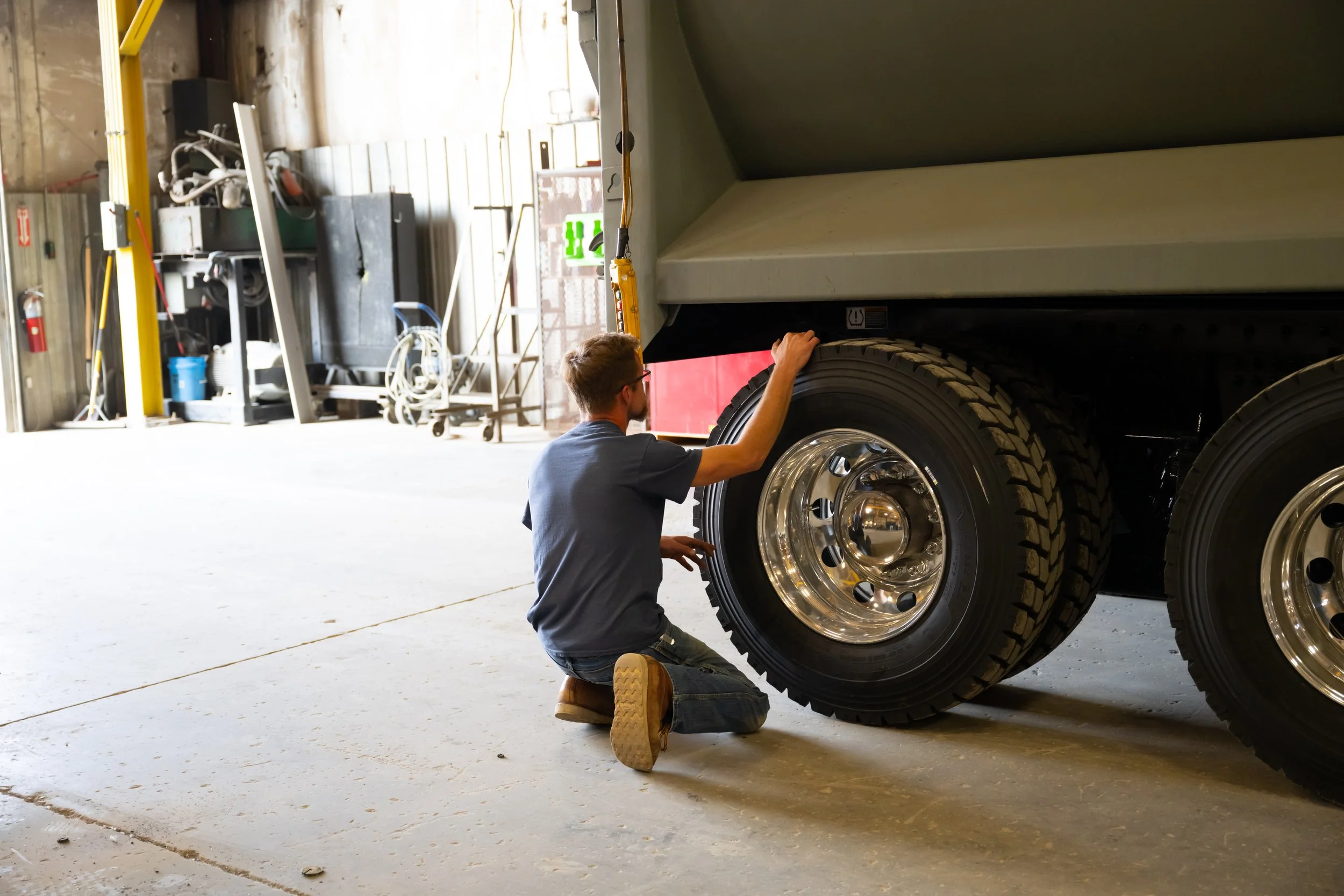 A worker on the ground, inspecting a tire