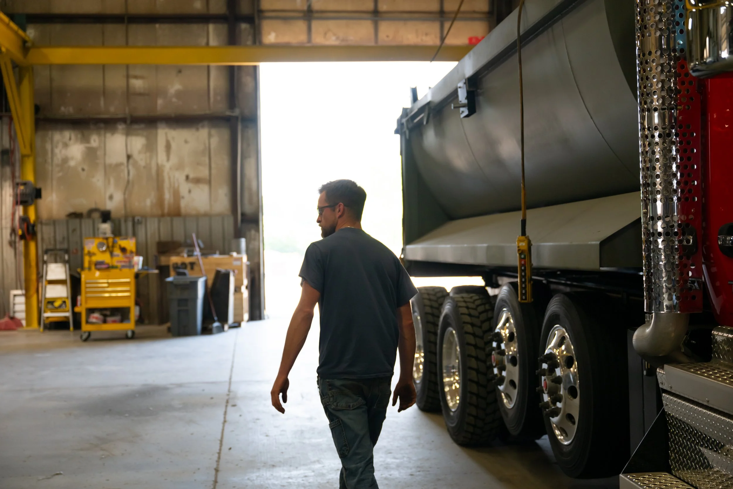An employee with his back turned, walking near a truck
