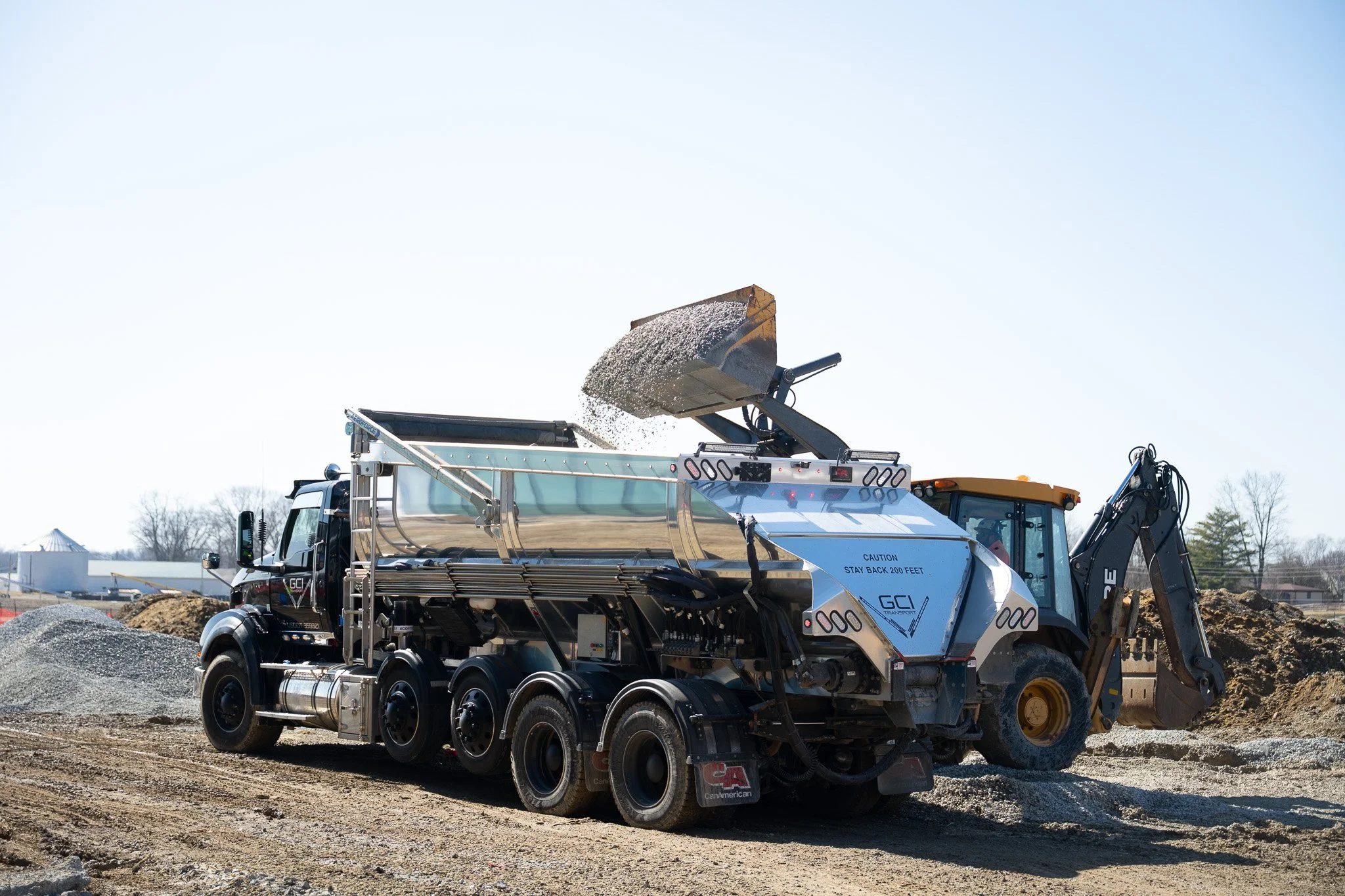 Gravel being placed into a gray truck bed