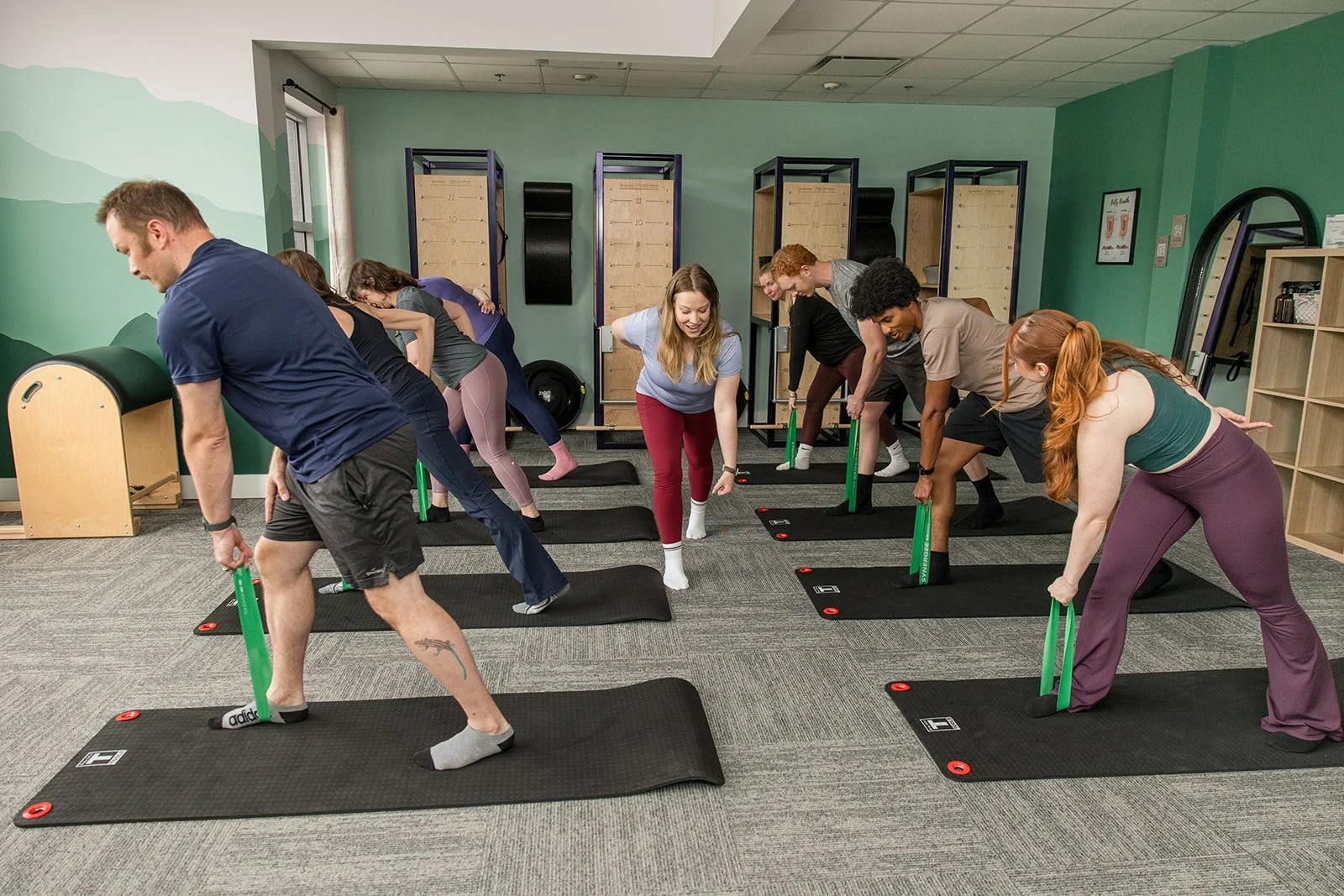 Pilates instructor demonstrating exercise to group class