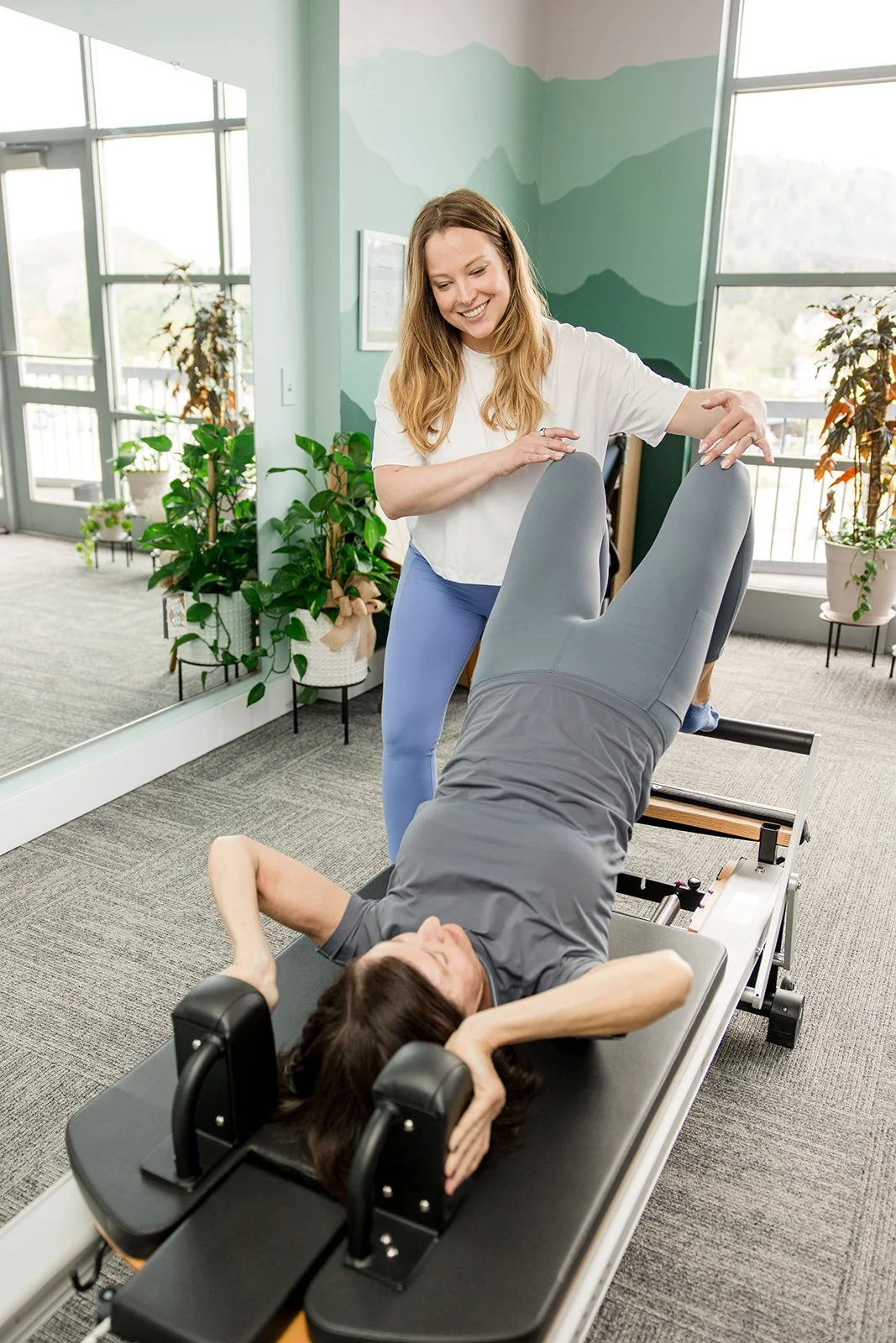 Pilates instructor smiling at client doing semicircle on the reformer