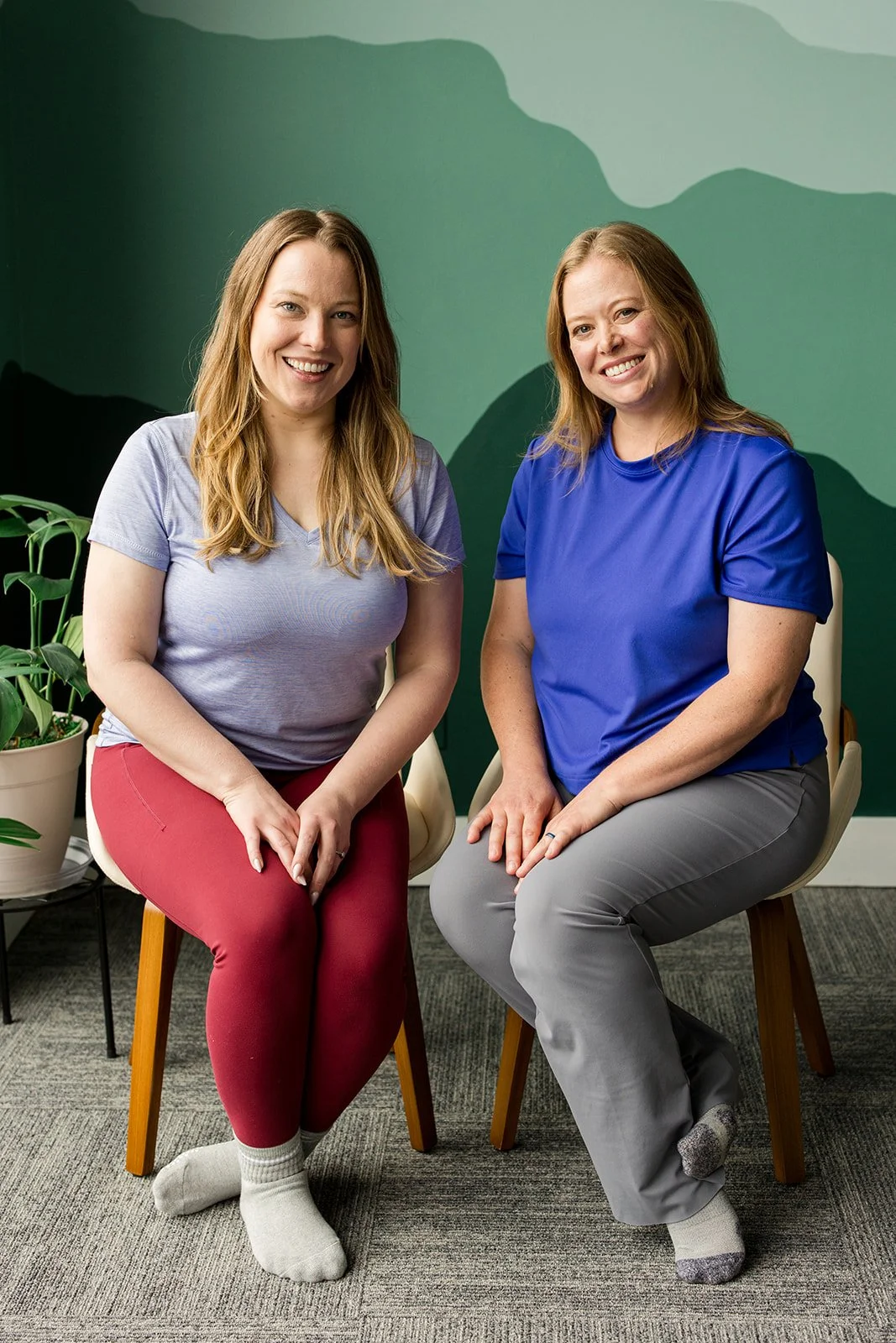 two sisters sit smiling for the camera