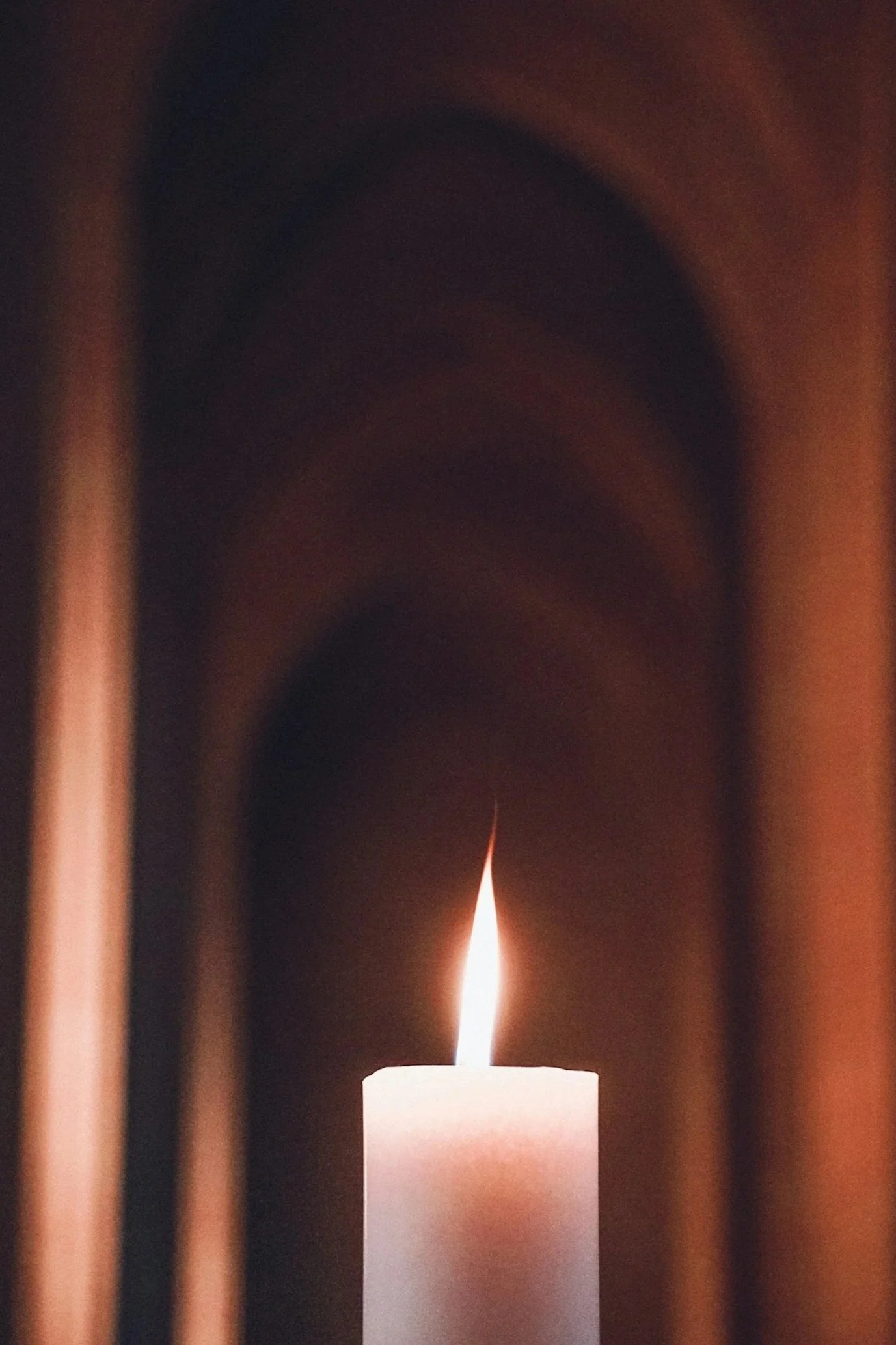 Lit white candle evoking historical and spiritual ambiance.