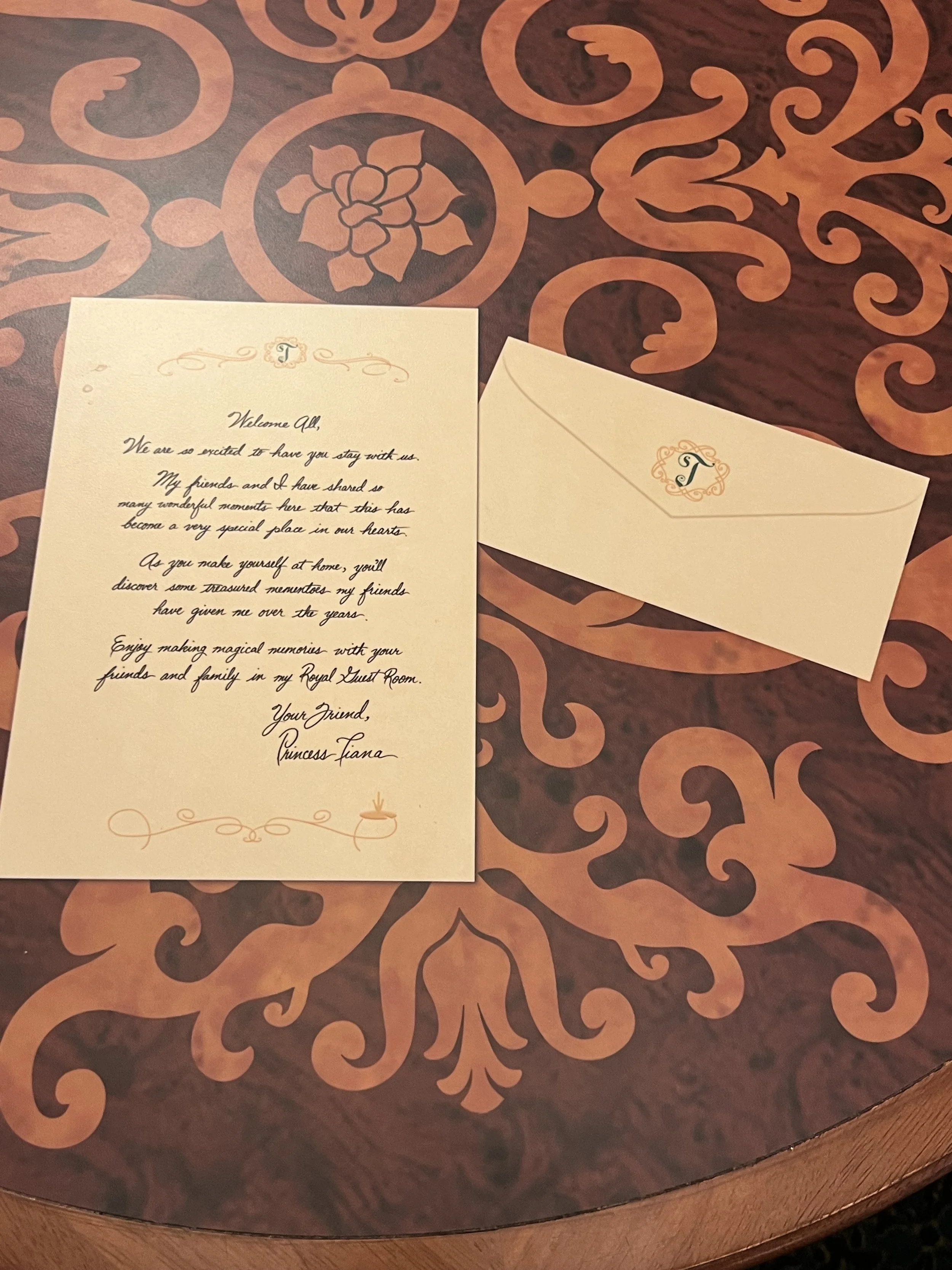 A letter and an envelope with monogram letter 'T' on a decorative table.