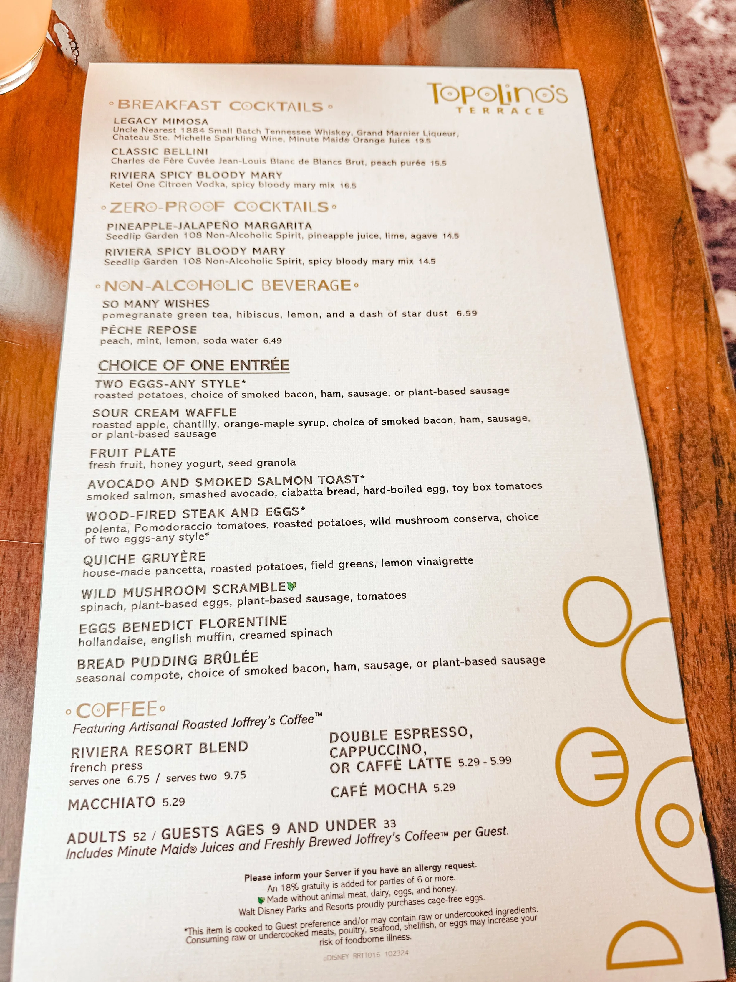 Menu from Topolino's Terrace featuring breakfast cocktails, zero-proof cocktails, non-alcoholic beverages, a choice of one entrée including egg dishes, waffles, toast, vegetable dishes, pasta, and pudding, as well as coffee options like espresso, cap