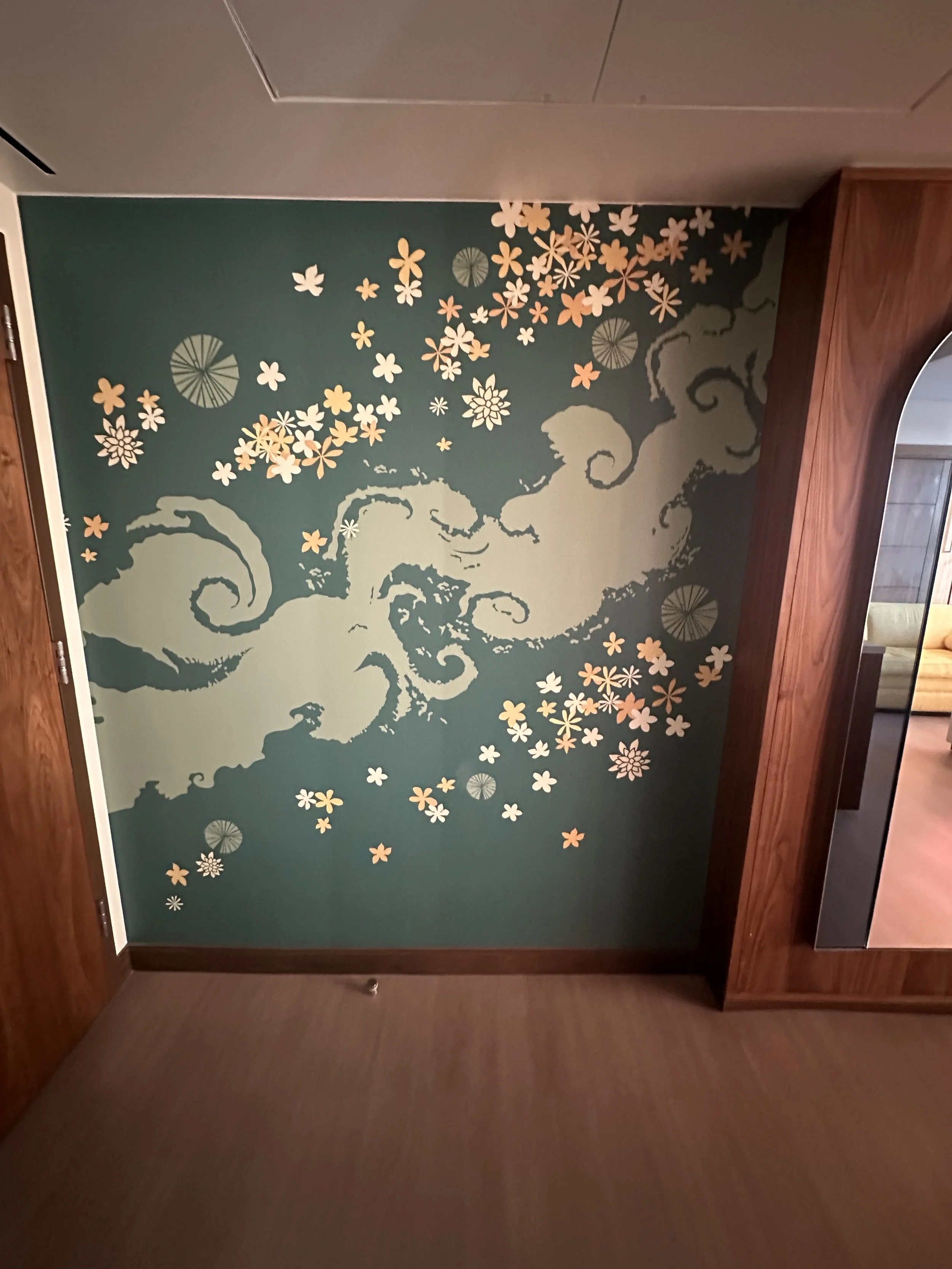 Decorative wall art featuring swirling clouds and falling cherry blossoms in soft pastel colors.