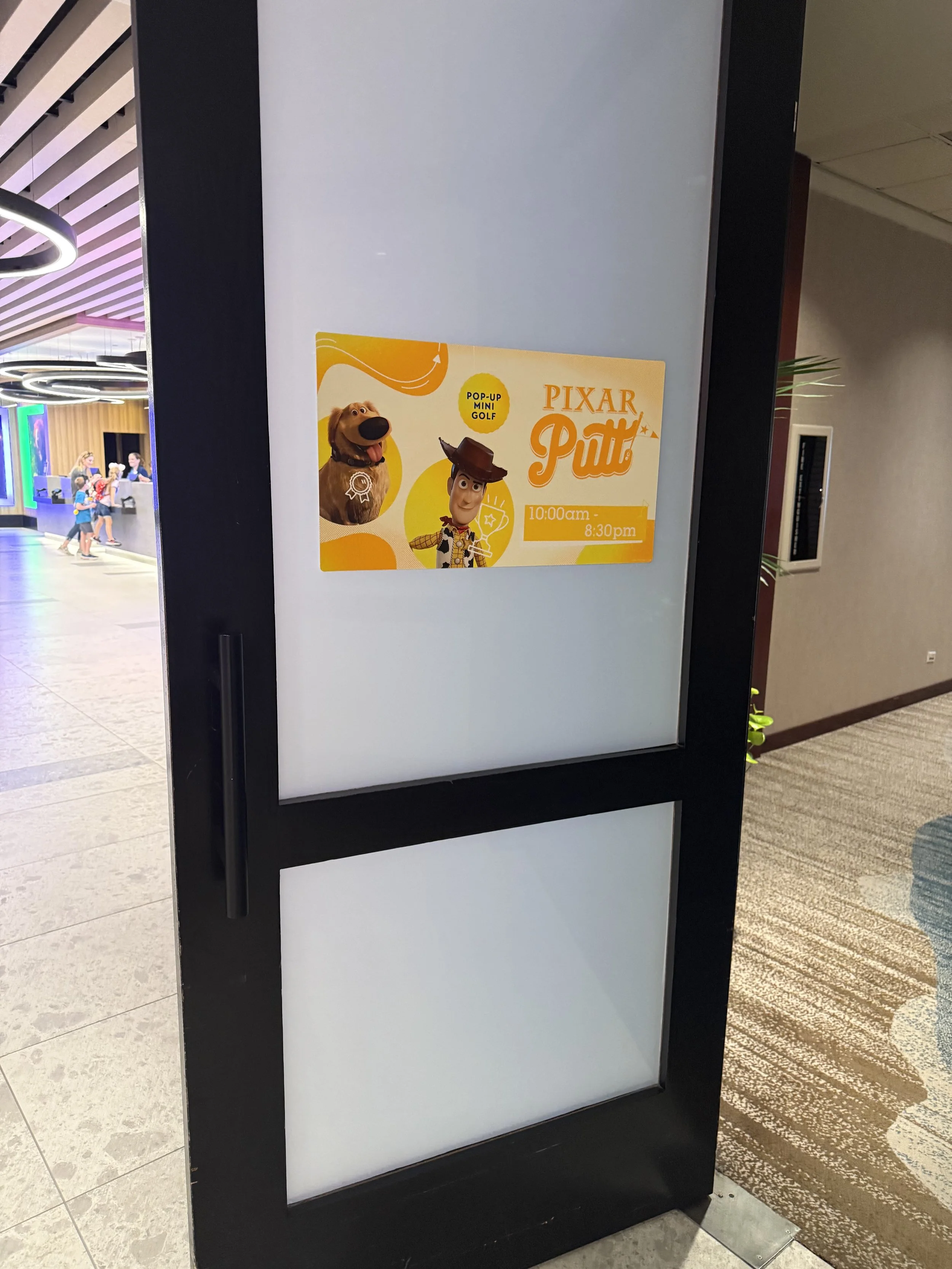 Sign advertising a Pixar Putt mini golf event, featuring characters from Toy Story, with event hours from 10:00 am to 8:30 pm.