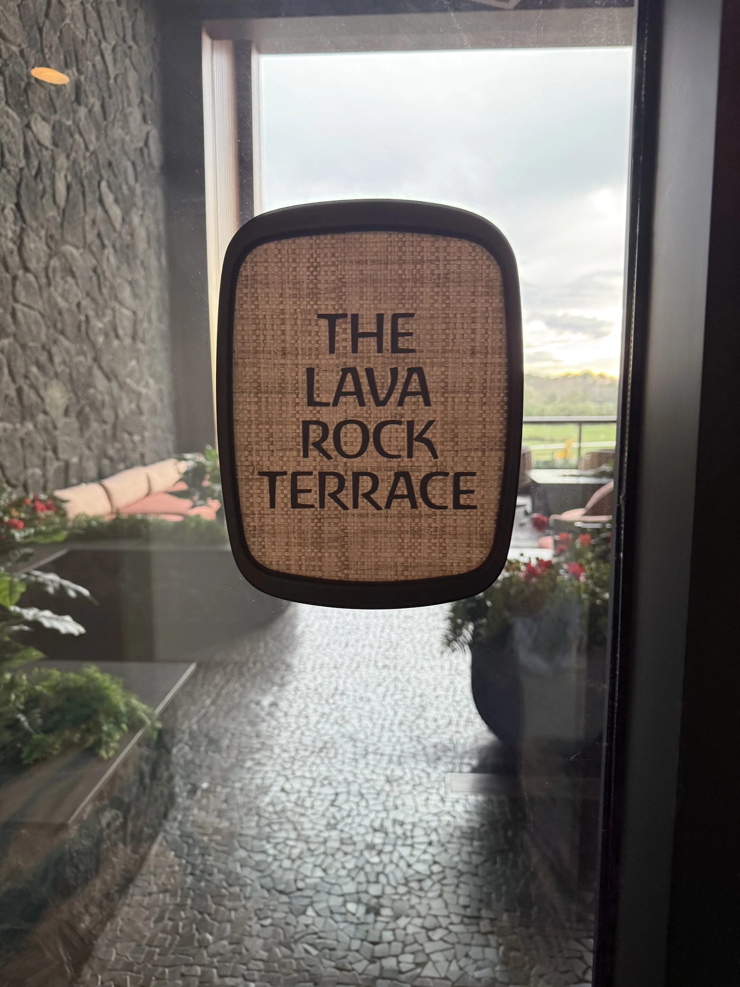 Door sign reading 'The Lava Rock Terrace' in black letters on a woven background.