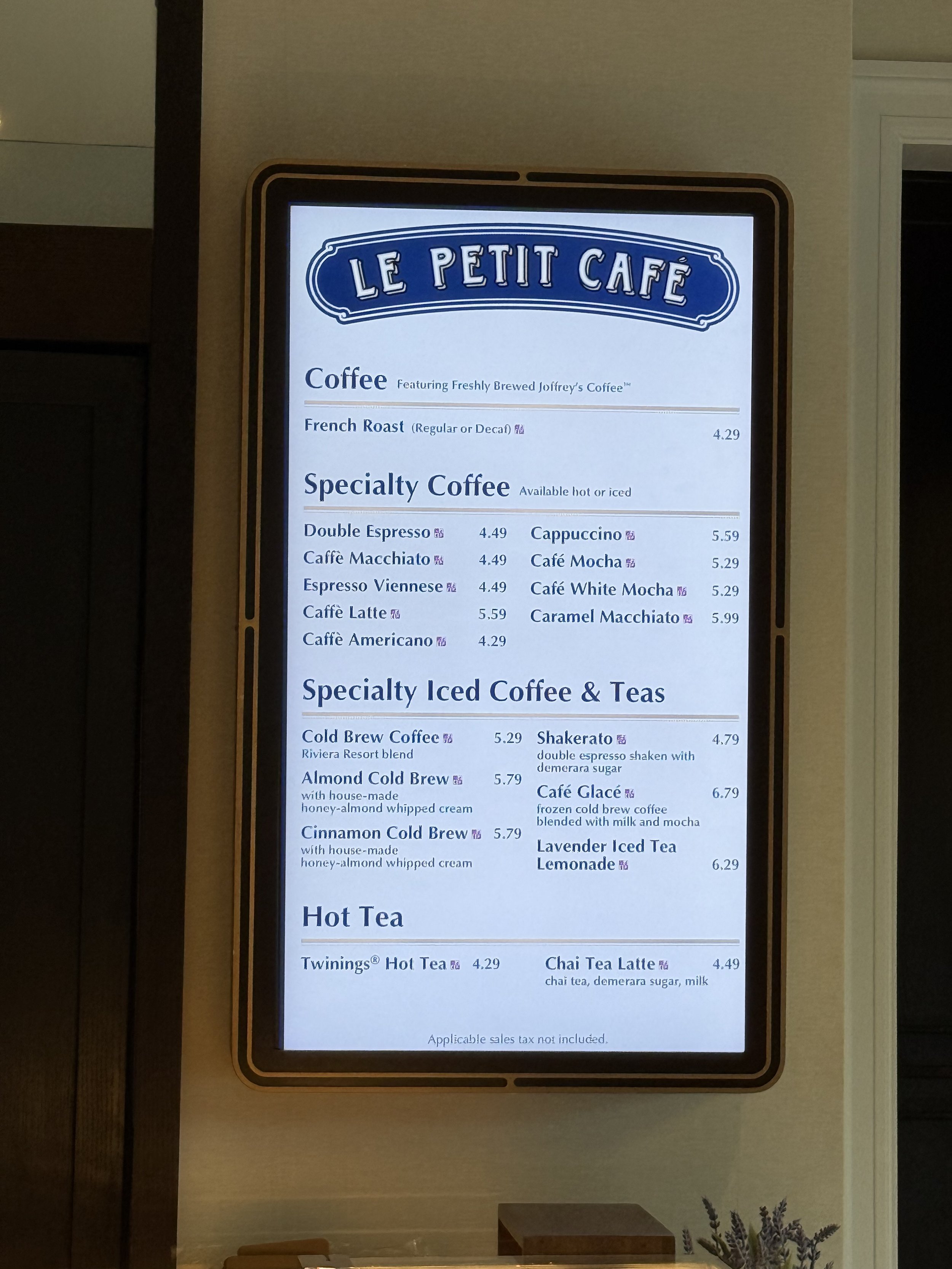 Restaurant menu board for Le Petit Café featuring coffee, specialty coffee, iced coffee and teas, hot tea, and their prices.