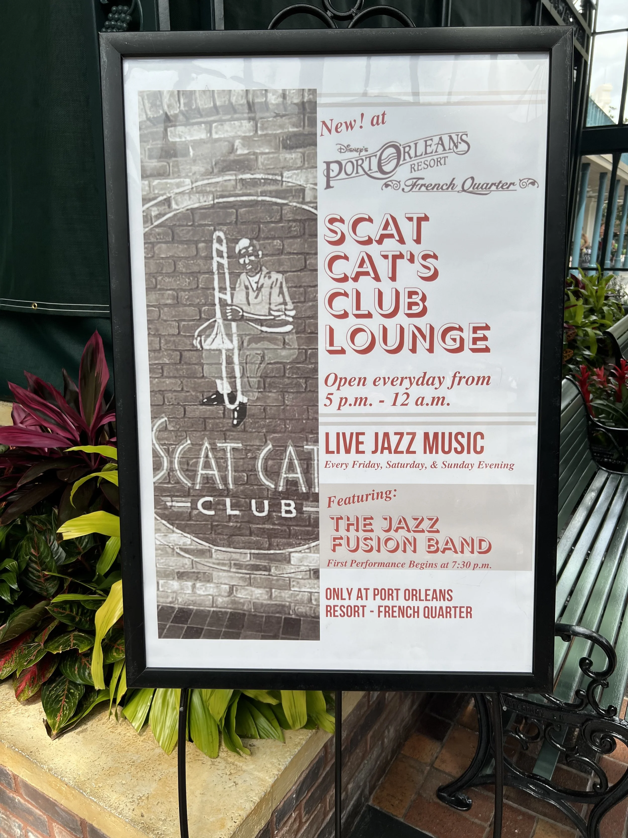 The sign advertises the Scat Cat's Club Lounge at Disney's Port Orleans Resort French Quarter, featuring live jazz music every Friday, Saturday, and Sunday evening, with the Jazz Fusion Band performing at 7:30 p.m. It indicates the lounge is open dai