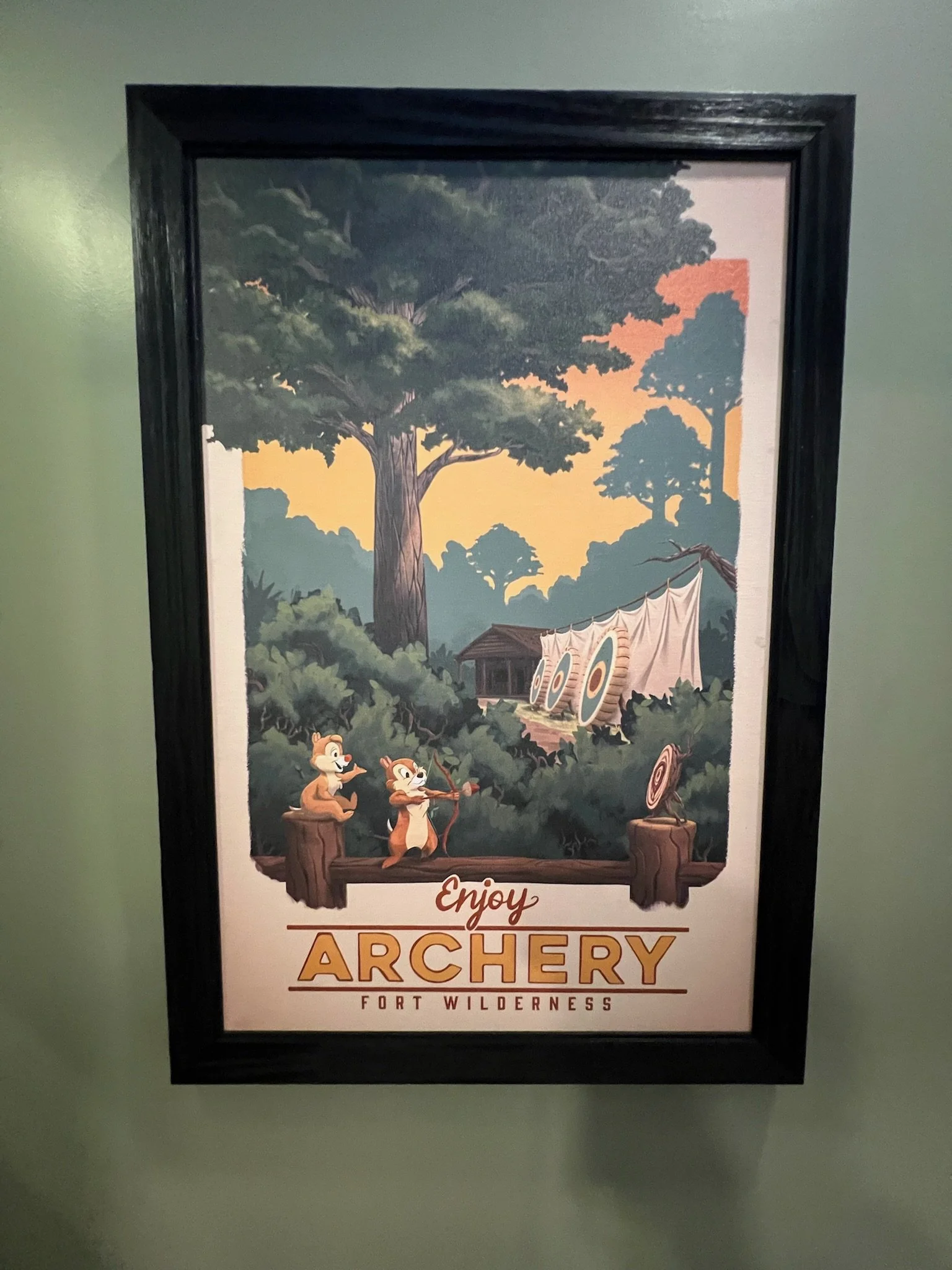 Poster promoting archery at Fort Wilderness showing cartoon animals aiming bows and arrows in a forest setting.