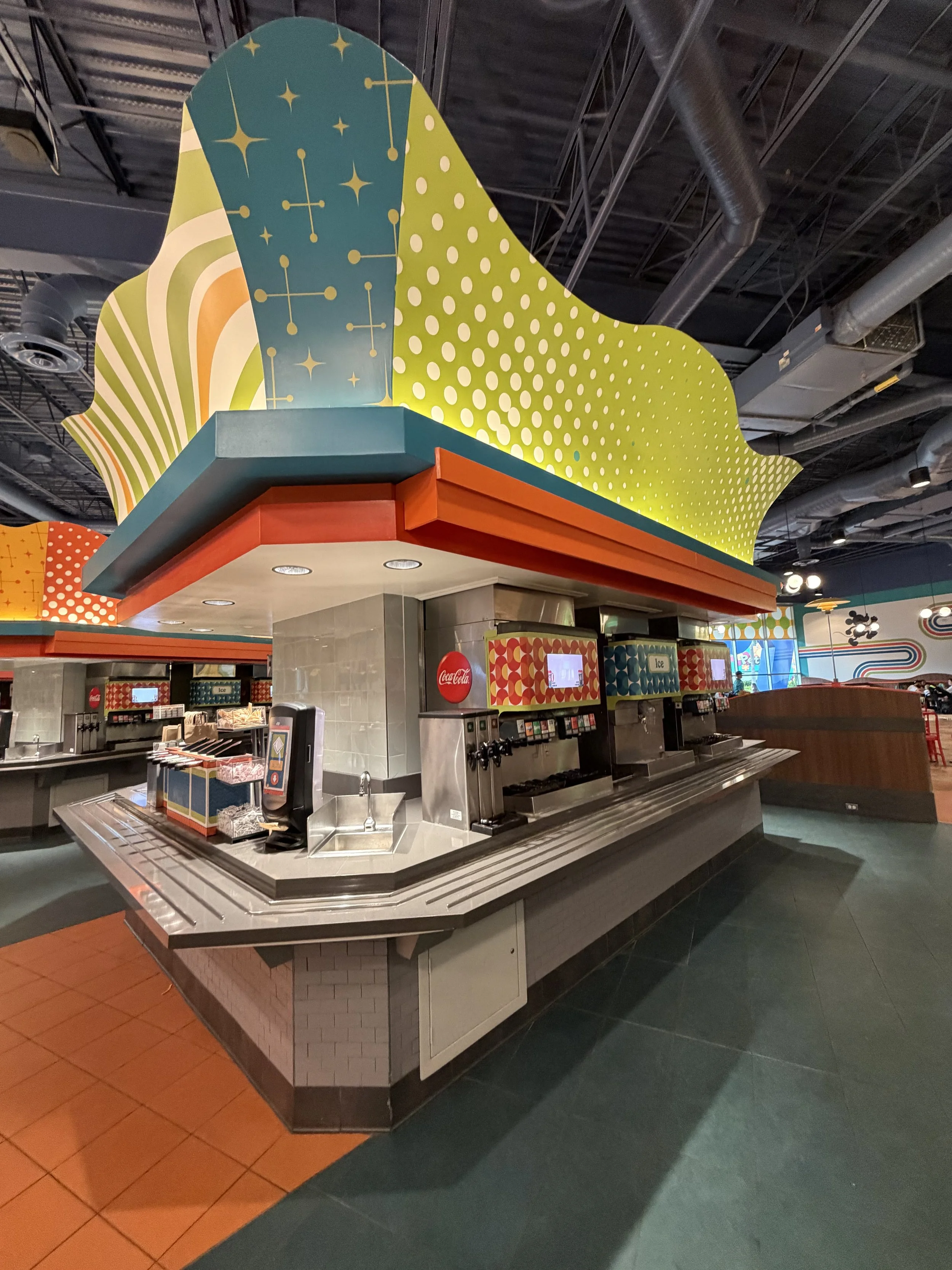 Colorful ice cream or snack bar counter with geometric patterns and whimsical design in a modern indoor eatery.