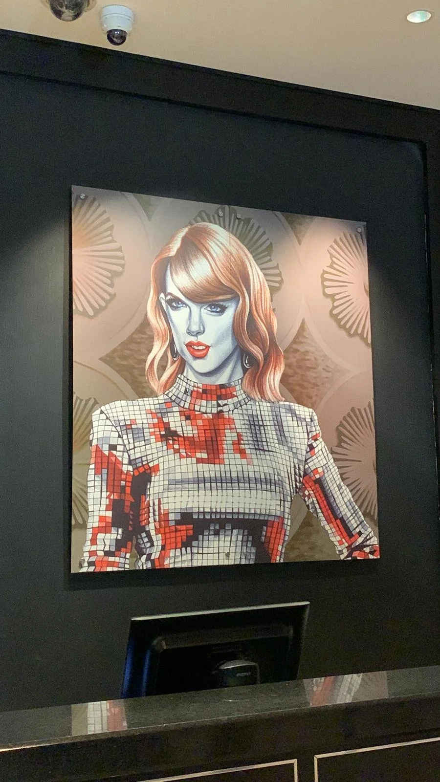 Digital artwork of a woman with red hair in a pixelated, mosaic style, wearing a patterned top, against a decorative background.