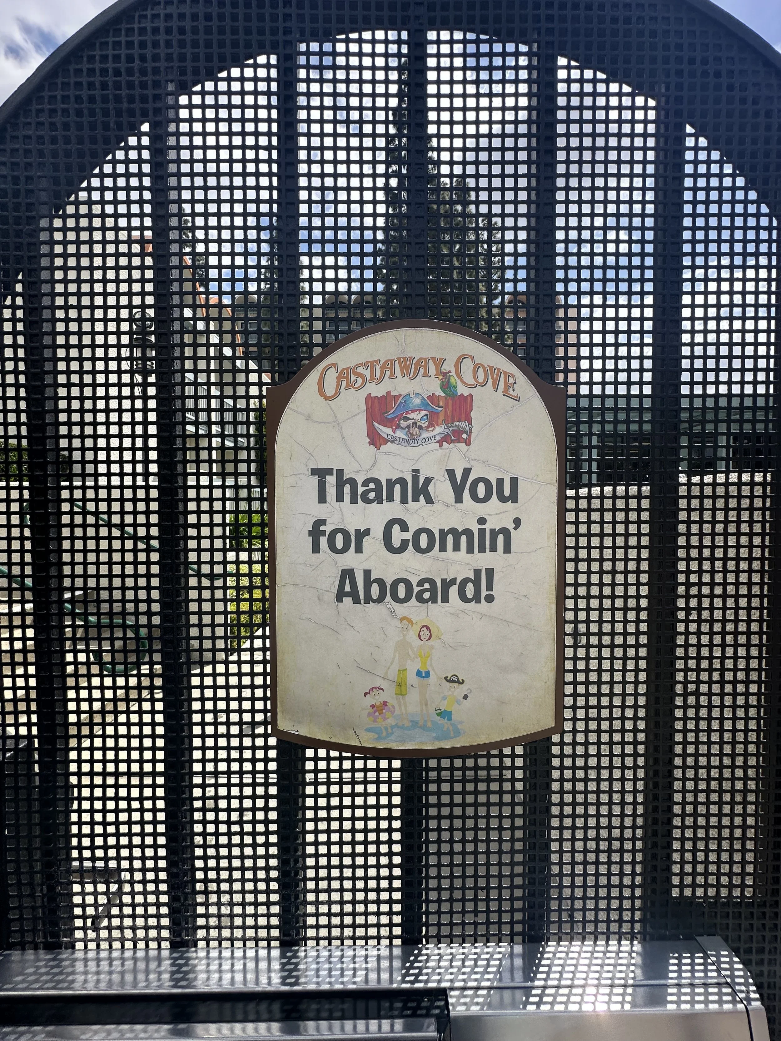 Sign at Castaway Cove water park with thank you message for visiting, featuring a cartoon of a woman and two children in swimwear.
