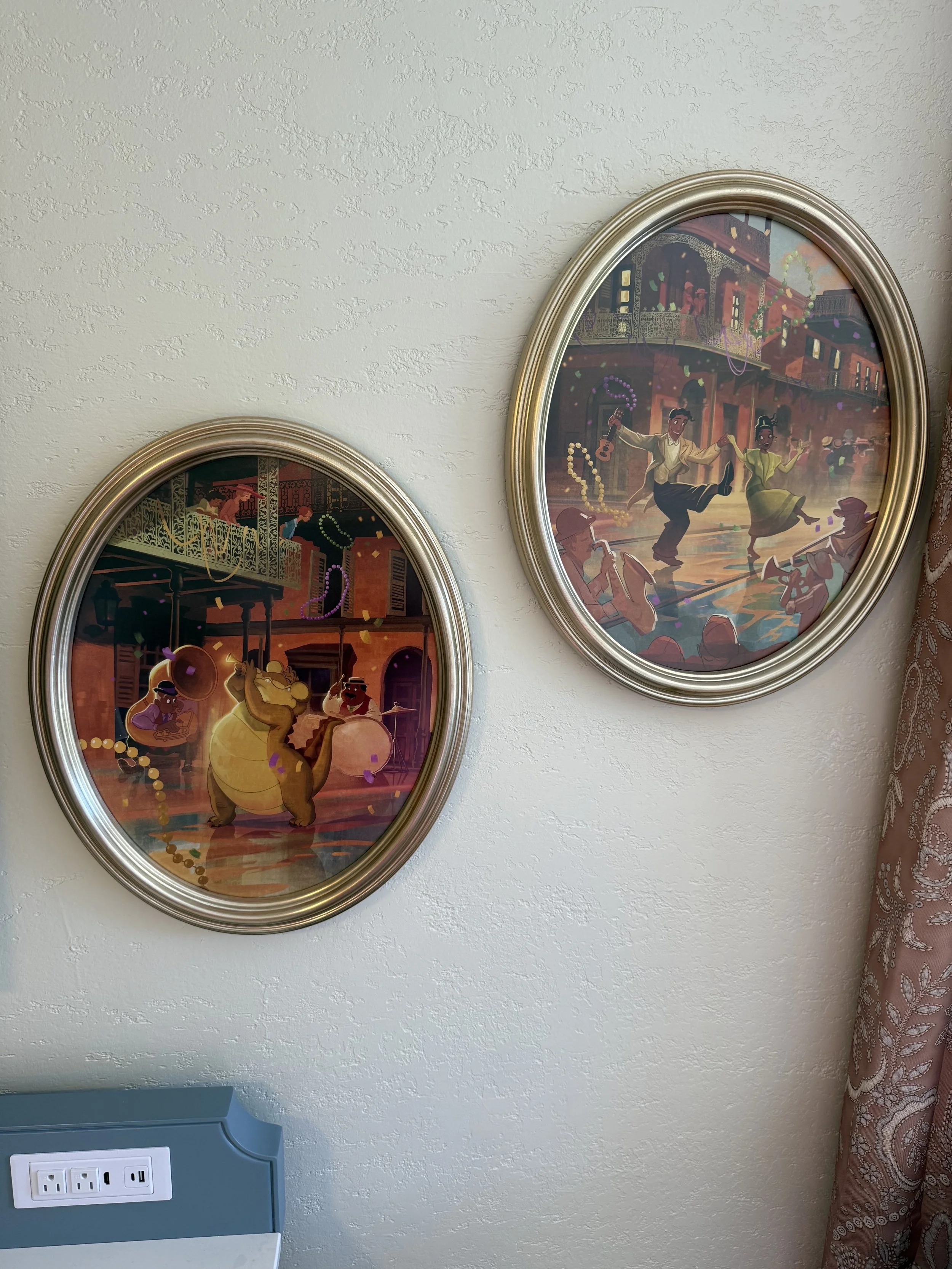 Two oval framed paintings depicting lively dance scenes with musicians, dancers, and a singing bear, with decorations and an urban setting in the background.